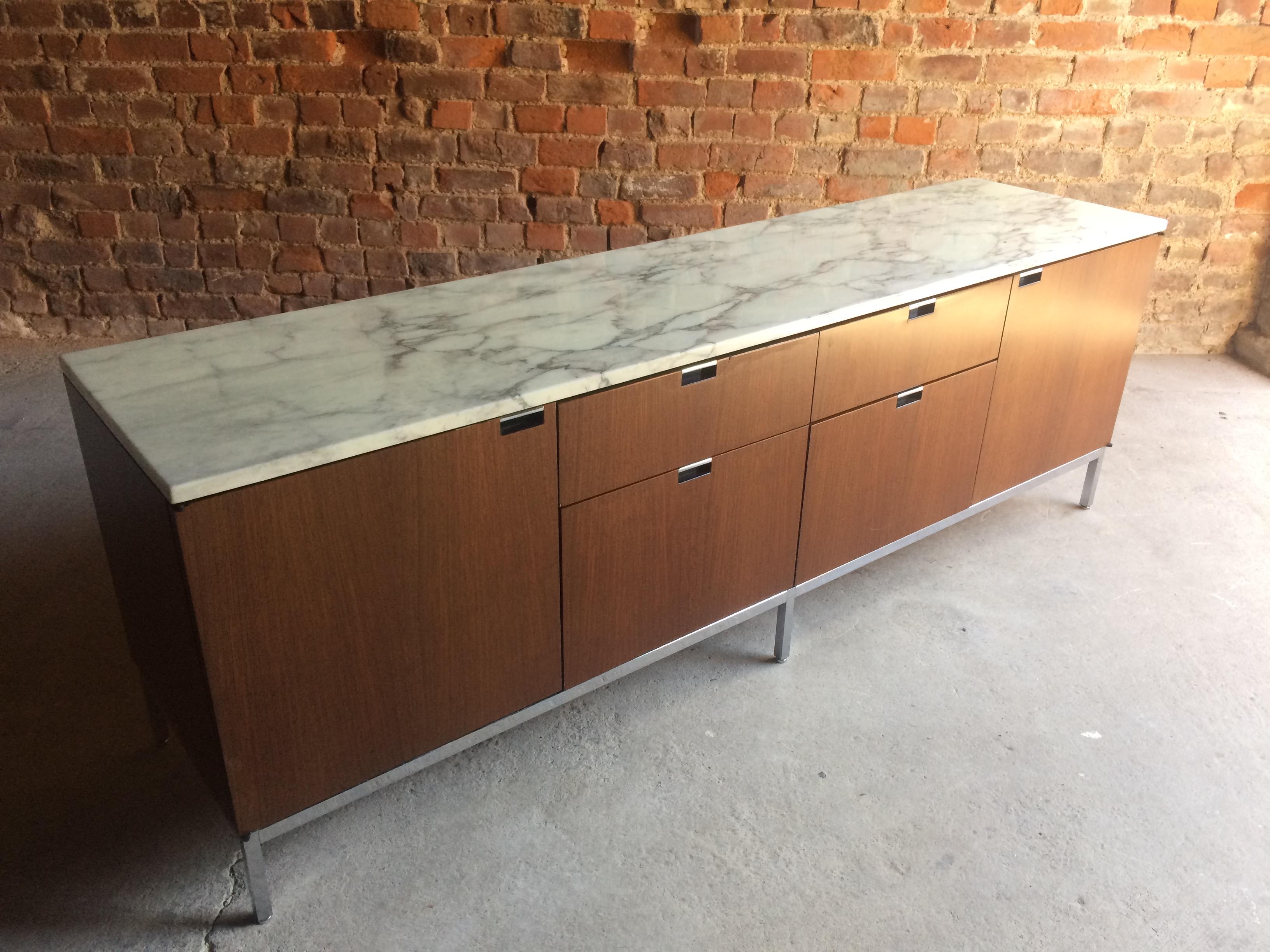 A stunningly beautiful iconic masterpiece by Florence Knoll, this light walnut credenza, carrara white marble top with soft grey veining running throughout over the long symetrical base with two cupboards to the sides with a bank of four drawers to