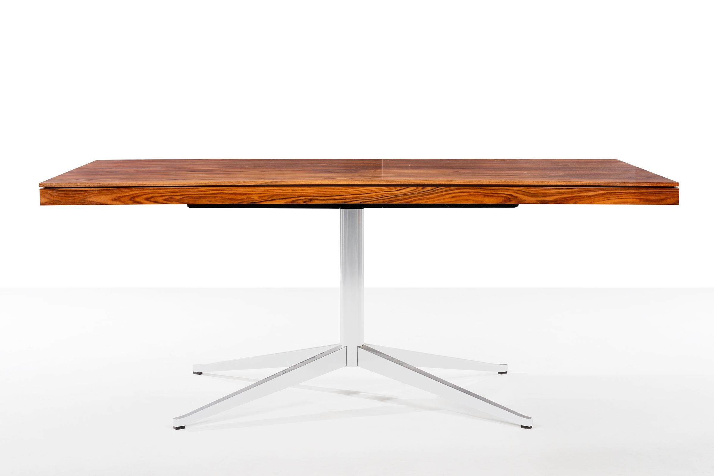 Florence Knoll rosewood desk, features bookmatched rosewood figured veneer with 2 pencil drawers and chrome-plated steel base.
 