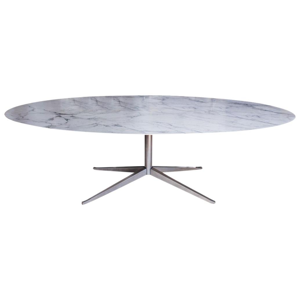 A conference / dining table by Florence Knoll for Knoll Inc. featuring an oval Calacatta marble top and chrome star-shaped base. Circa 2000 production.