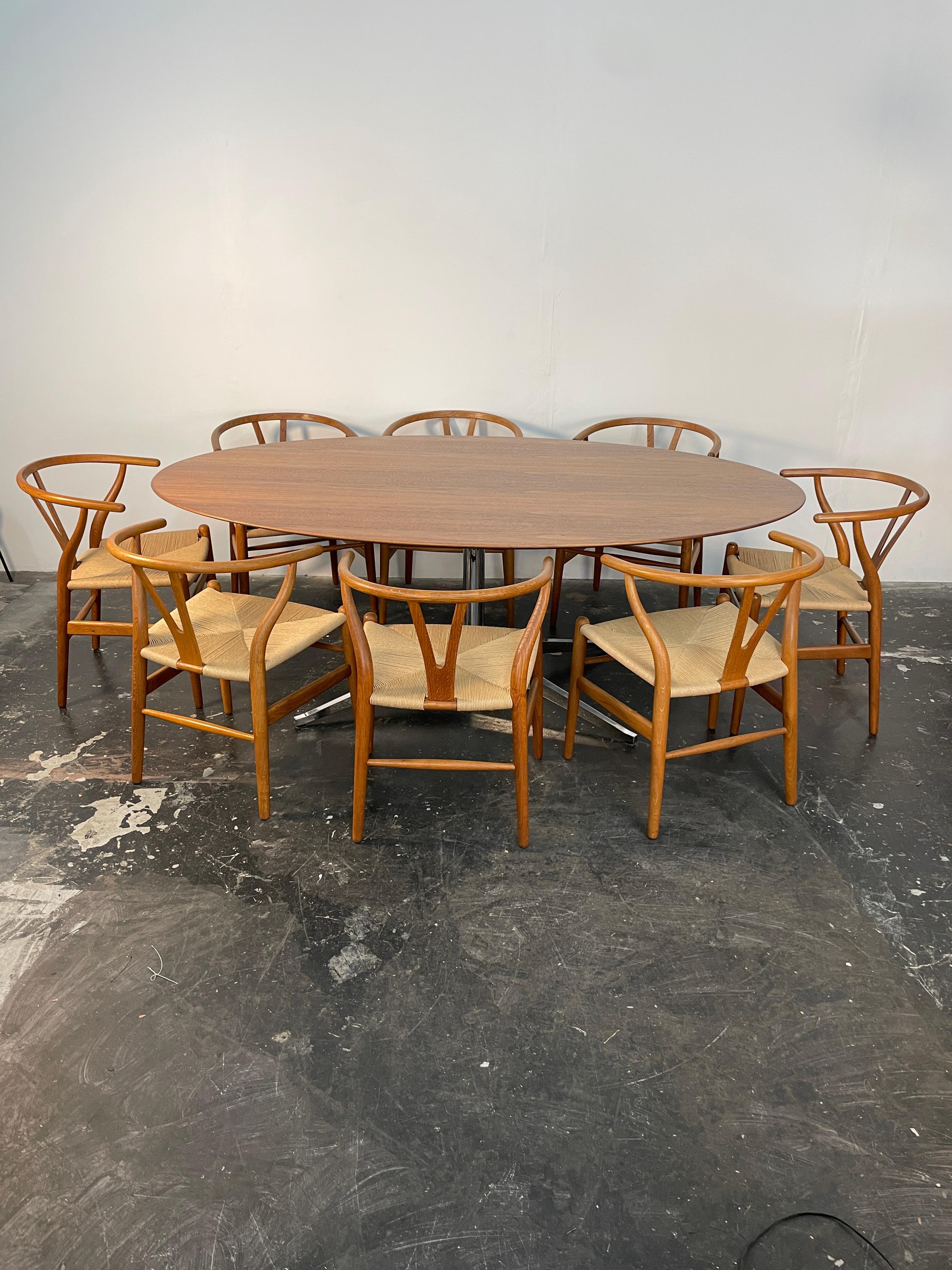Versatile iconic table designed by Florence Knoll for Knoll International in the United States circa 1960s. This design features an oval walnut wood top that sits over a chromed metal four-star base perfectly proportioned to stand the test of time.