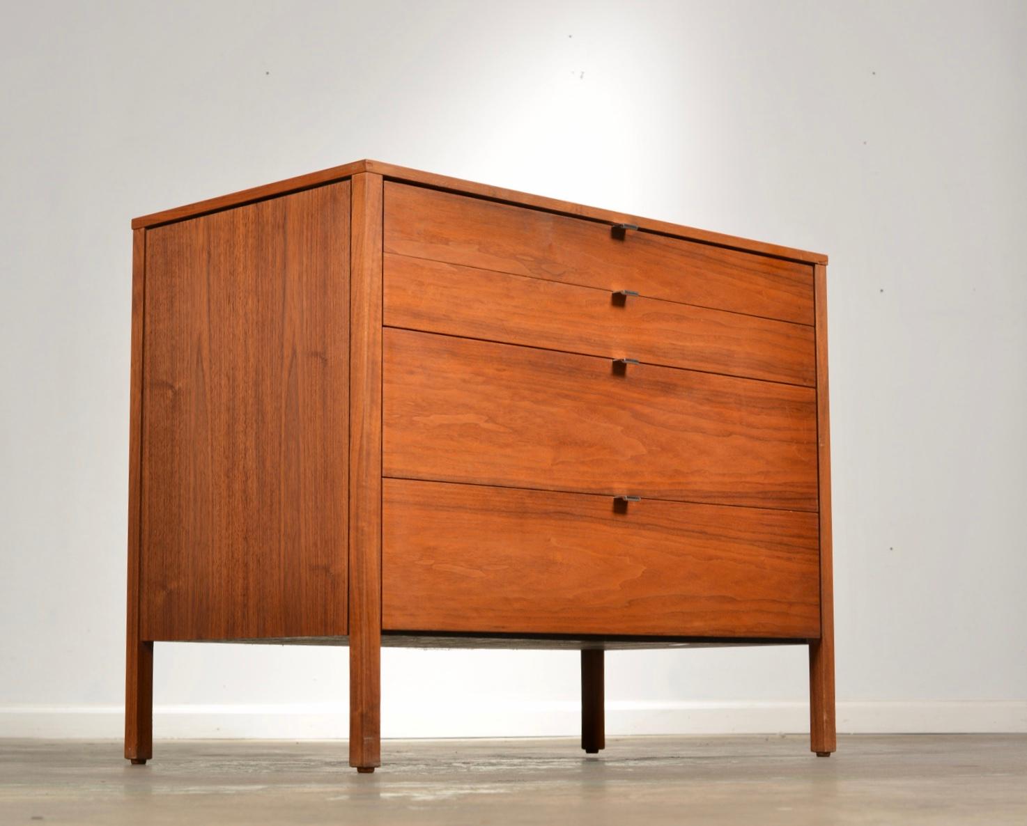 Pair of low walnut dressers designed by Florence Knoll. These have black anodized aluminum pulls. The backs are finished with a white laminate.  Priced as a set of 2, also available individually, please inquire for pricing. 

All items are viewable