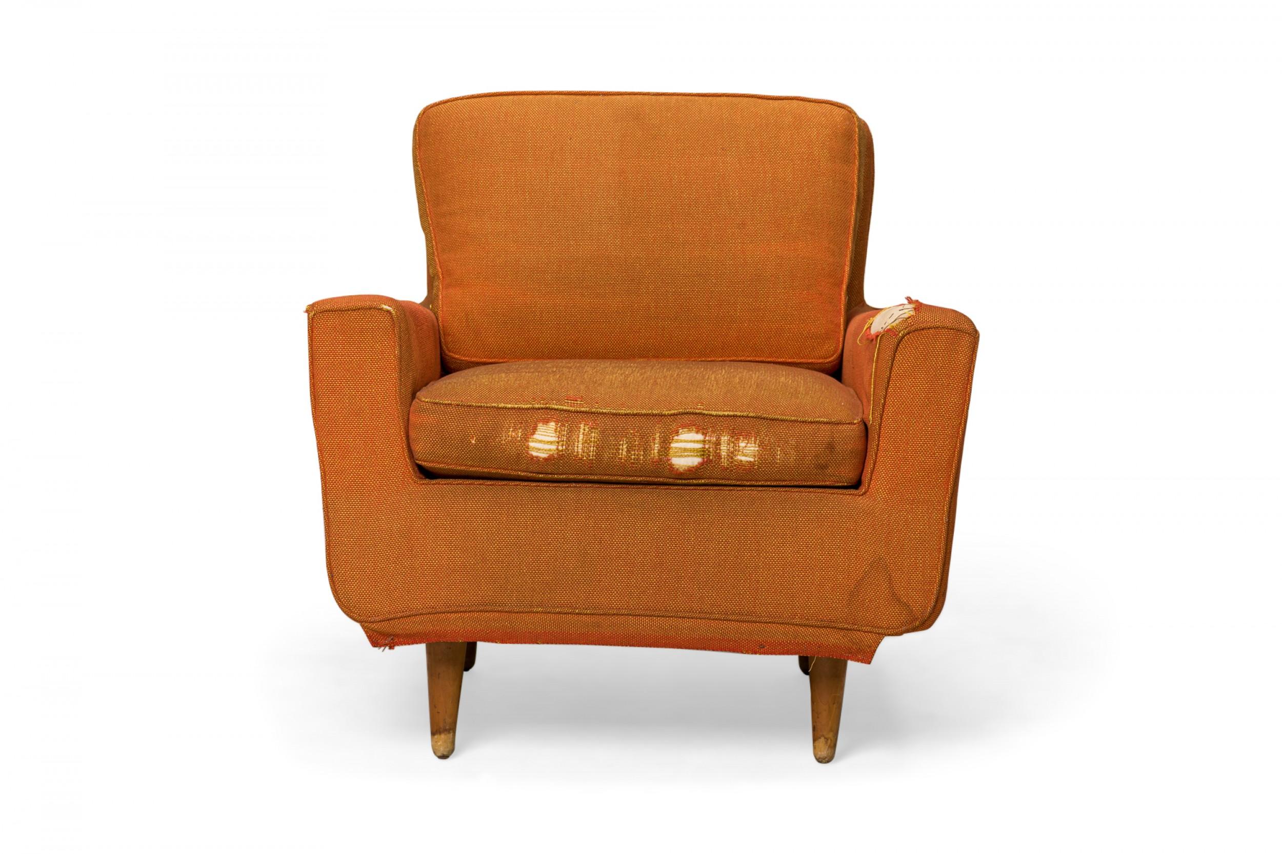 American mid-century lounge armchair with textured orange fabric upholstery, resting on four broad tapered wooden legs. (FLORENCE KNOLL FOR KNOLL INTERNATIONAL)