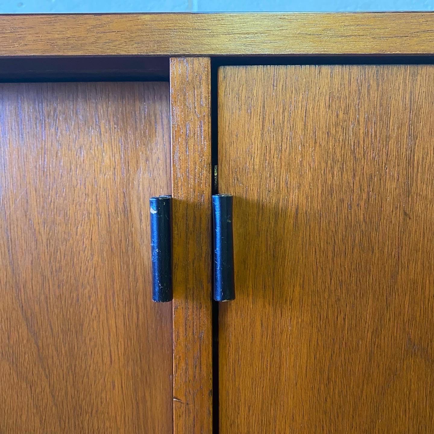 This is a nice walnut credenza with heavy duty laminate top, leather pulls and chrome legs designed by Florence Knoll for Knoll International. The credenza includes 6 shelves and one large pull out filing cabinet that could be used for storage.