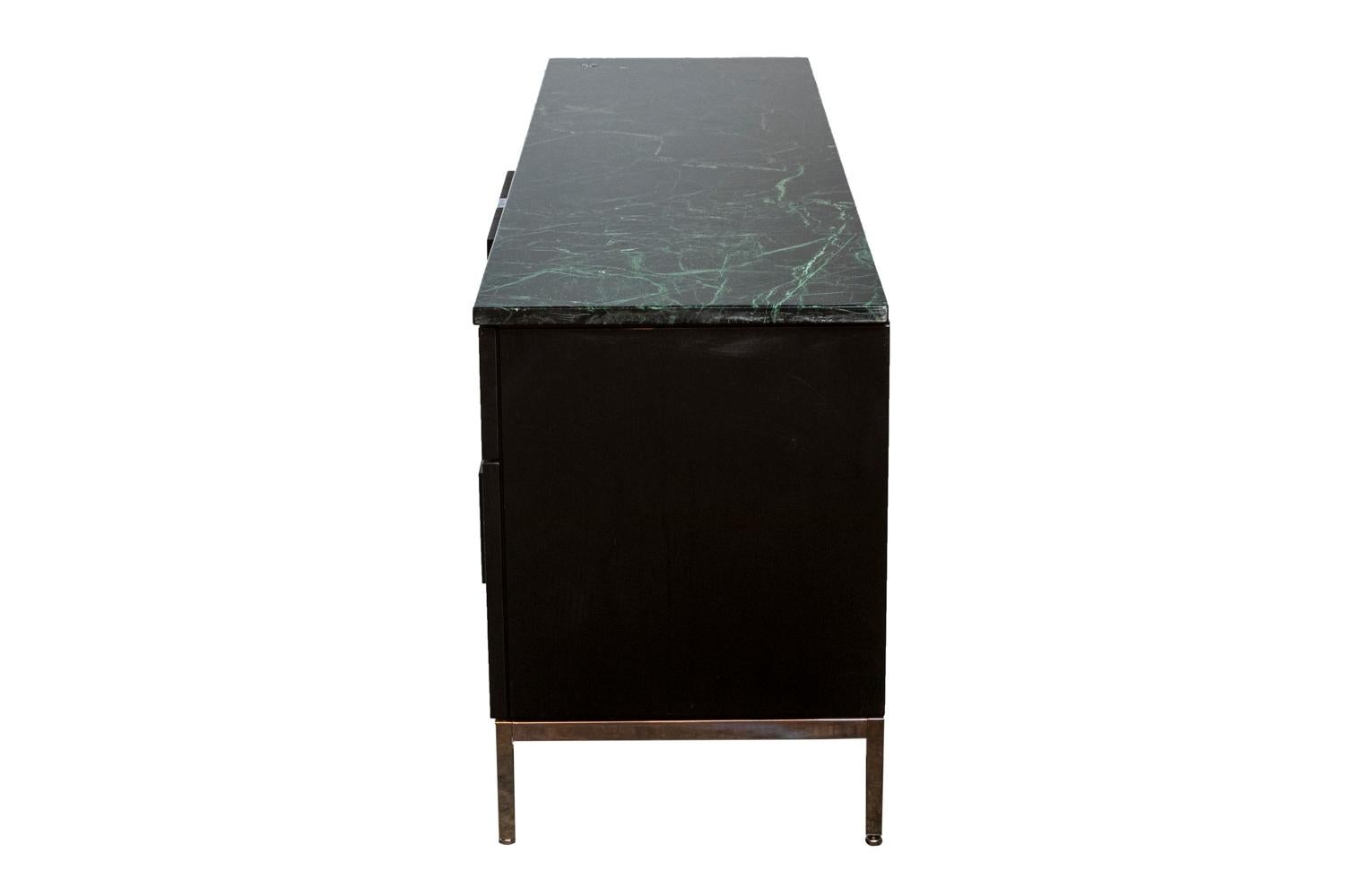 Florence Knoll, attributed to.
Knoll International, edited by. 

Sideboard. Black lacquered oak cabinet. White veined black marble top. Square-section, chromed tubular steel base. Four front compartments, two opening onto shelves and two with