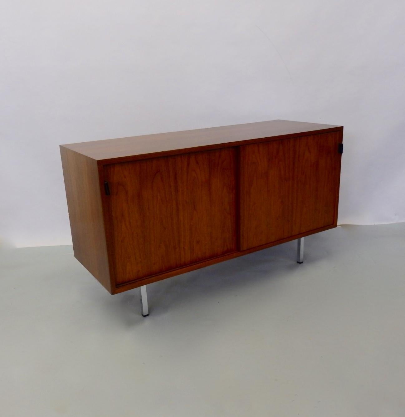 Nice walnut cabinet with file drawer on one side four drawers on the other. All behind sliding doors with leather pulls. Cabinet recently refinished. Pulls in excellent condition. Knoll label intact.