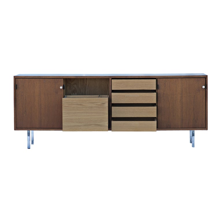 A Classic and iconic Mid-Century Modern credenza designed by Florence Knoll for Knoll c. 1950s.
 
A walnut case with polished chrome legs and leather pulls. The interior consists of drawers, a file drawer, a pull out shelf, and adjustable shelves.