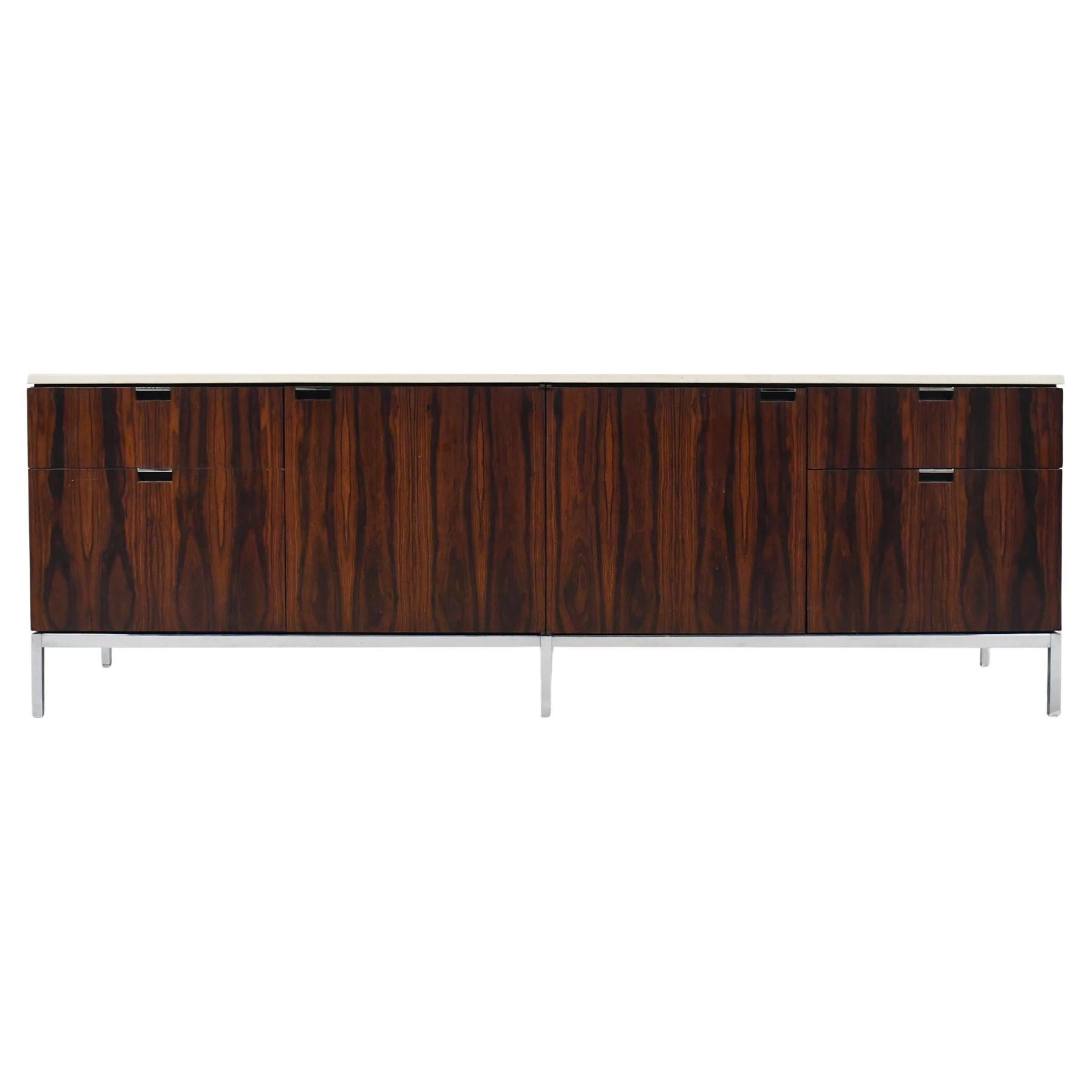 A classic design by Florence Knoll, the 'four position' credenza is an elegant cabinet appointed with many refined details. Supported by a polished chrome steel base, the case is veneered in vertically matched rosewood and has a beautiful marble top