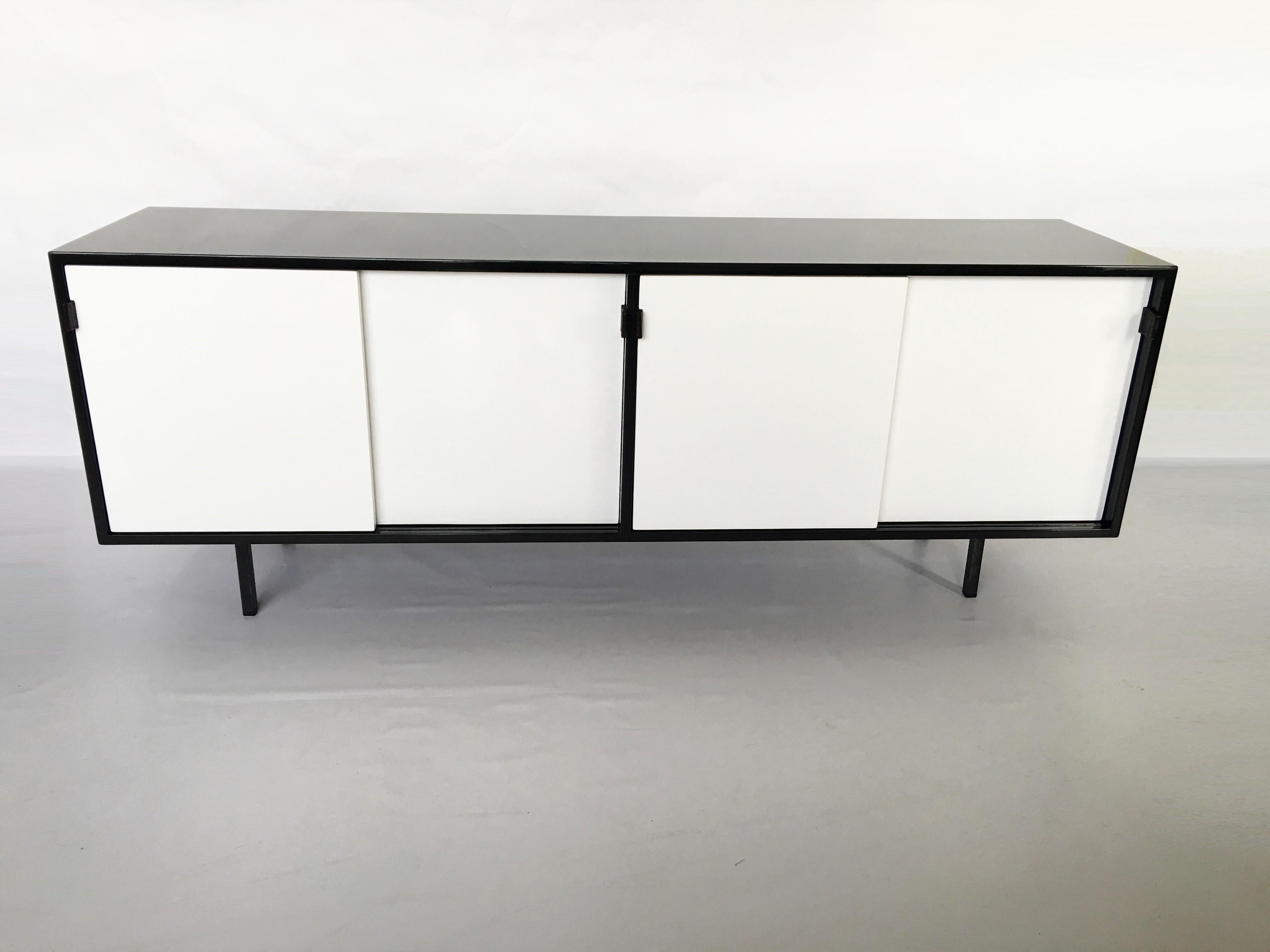 A very nice sideboard from Florence Knoll edited and signed by Knoll International, circa 1950s. The cabinet features four sliding drawers with leather pulls that reveal shelf within each. Adjustable shelves allow for internal configuration to suit