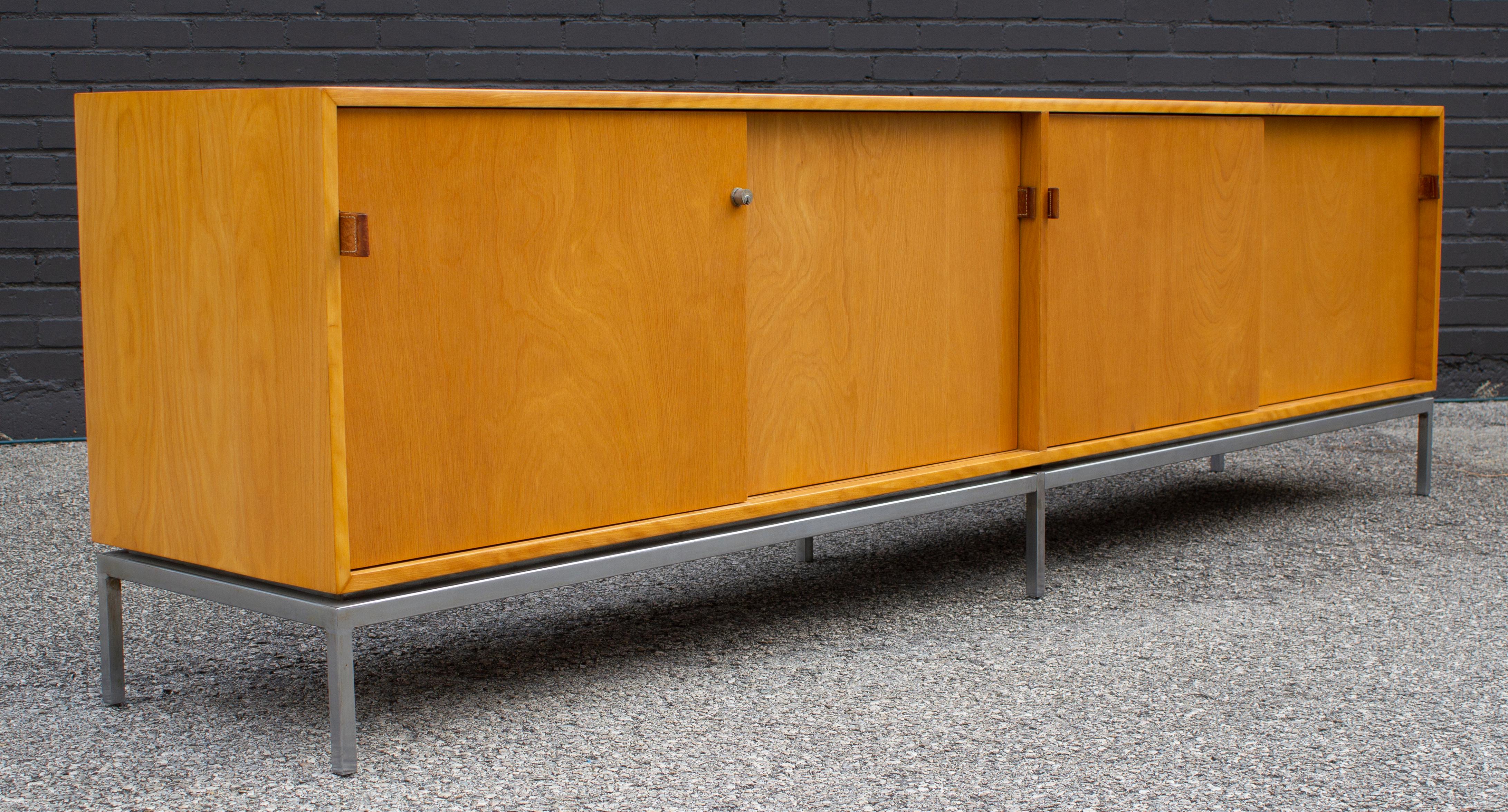 Early and rare credenza in maple by Florence Knoll for Knoll International. This classic modern icon is absolutely amazing and was constructed with a beautiful maple, oak drawers, natural leather pulls and sits on a satin steel base. The credenza