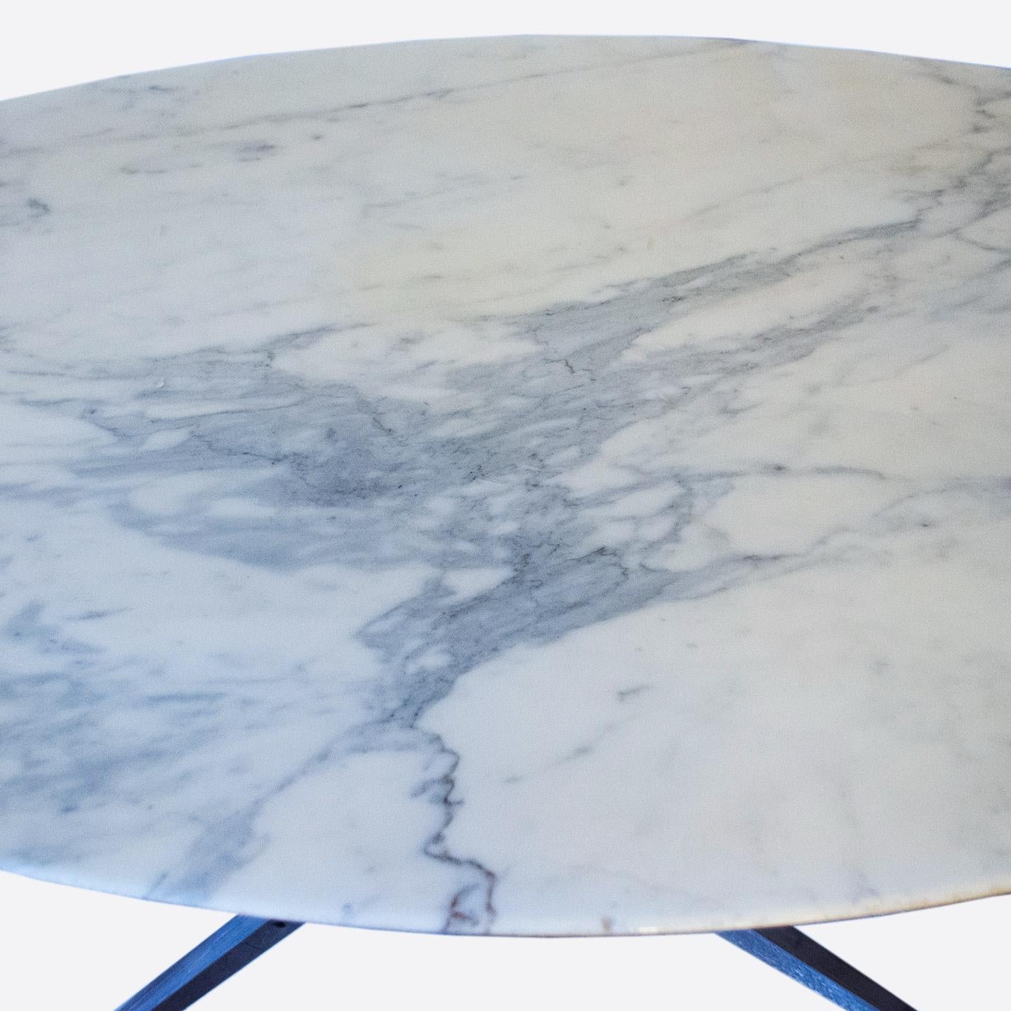 This Florence Knoll's iconic Mid-Century Modern oval dining table was designed and produced in the 1960's. The luxurious marble table top features a beautiful cool gray veining throughout and is set on a heavy gauge chromed steel base with four