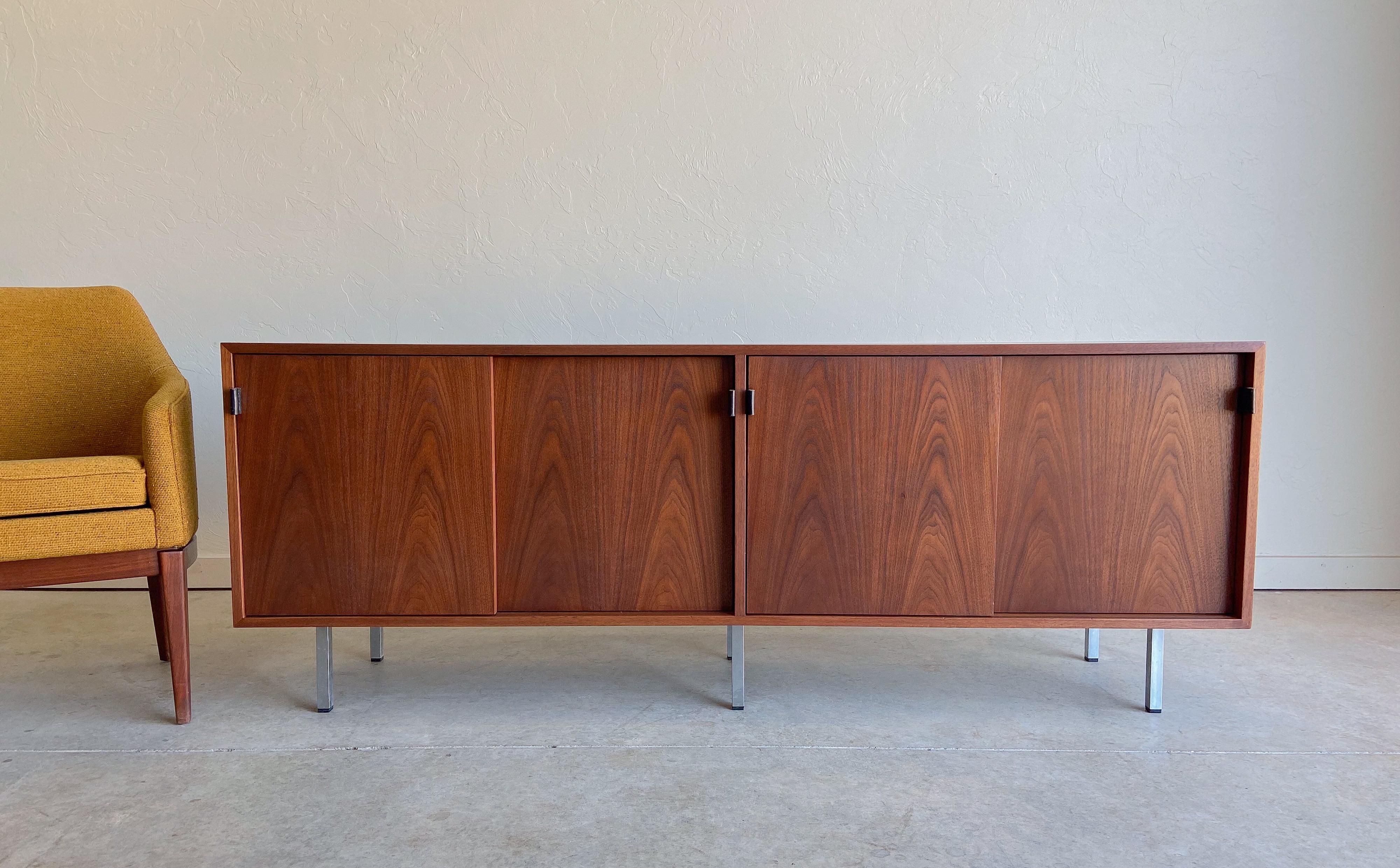 Offered is a beautifully grained walnut credenza designed by Florence Knoll for Knoll International.

A perfect representation of form and function. Featuring four sliding doors behind which are a total of eight drawers, and four adjustable