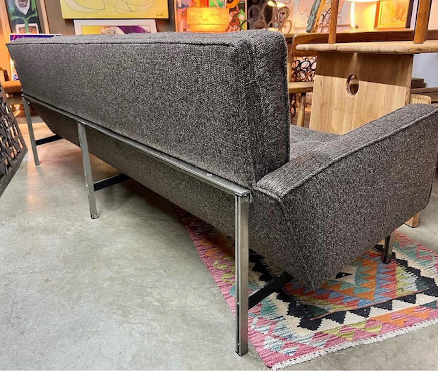 Newly upholstered mid-century modern Florence Knoll 'Parallel Bar' sofa with chrome legs and back base feature a charcoal grey color and is in great vintage condition.  
Dimensions: 90.5