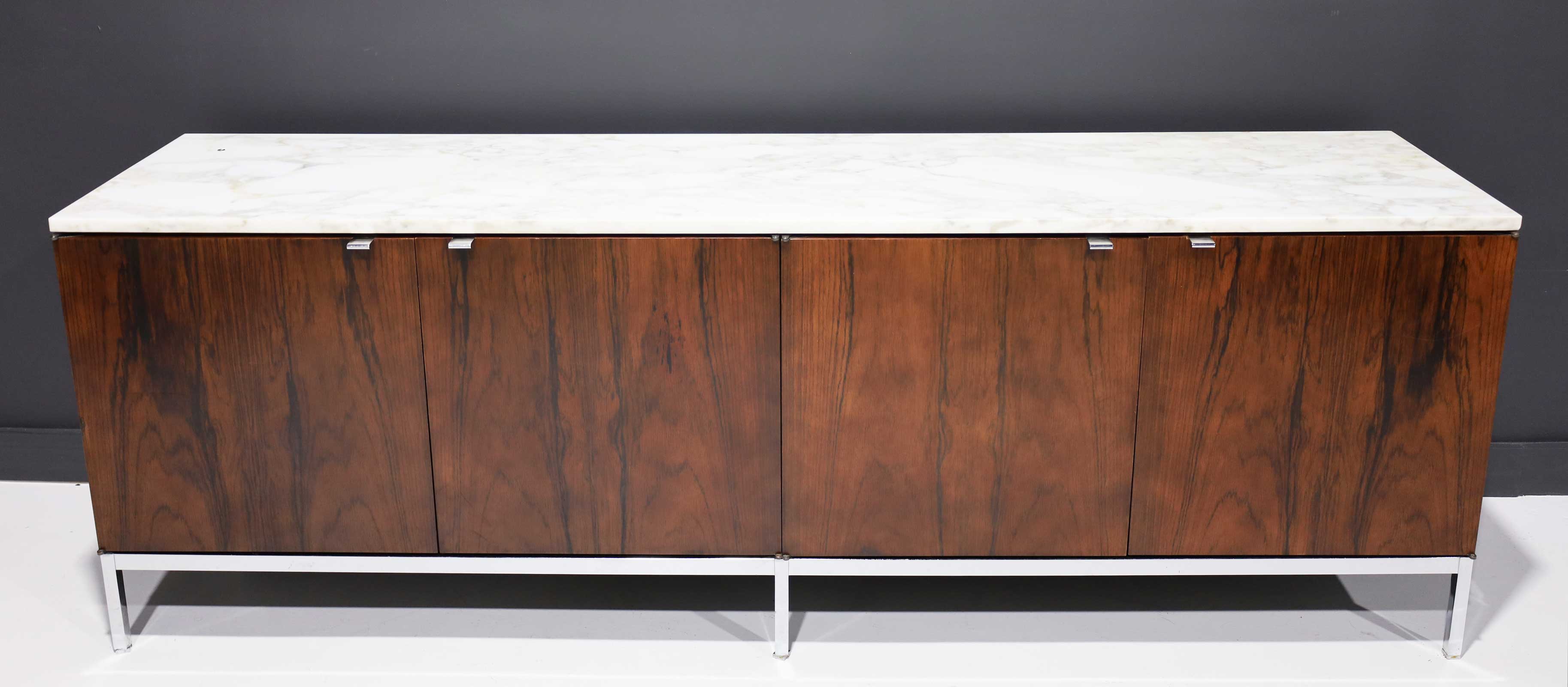 Florence Knoll's iconic sideboard/credenza in rosewood with calacutta marble top. The sideboard features 4 bays with internal shelving in each bay. Key not available. In beautiful condition with no issues. 1960s. From a prominent single owner