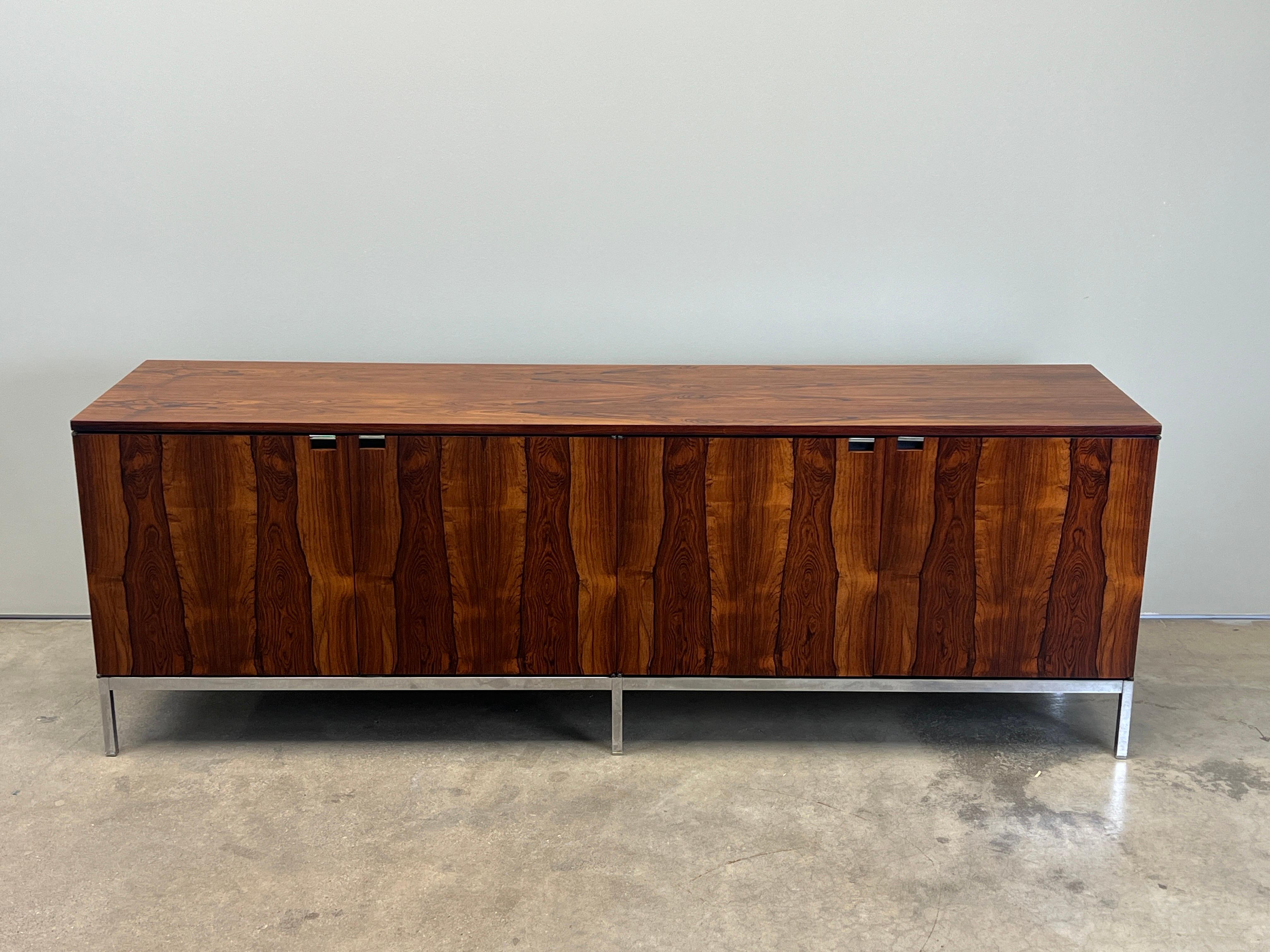 Un mobile in palissandro dalle venature espressive disegnato da Florence Knoll per Knoll. Interno in Oak con ripiani regolabili. 
