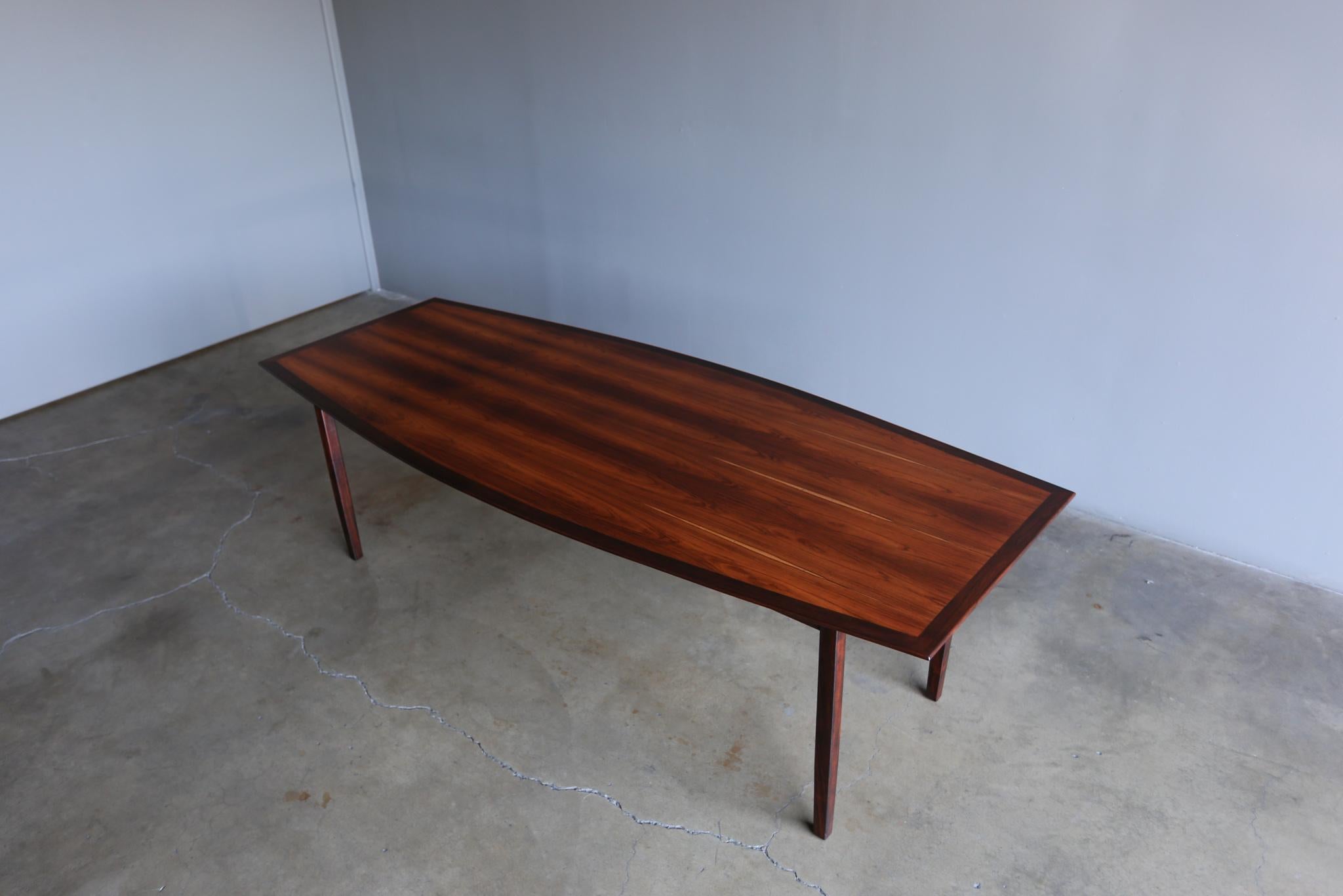 Florence Knoll Highly Figured Rosewood Boat Shaped Dining Table Distributed by FORMA Brazil,  circa 1960.  This table has been professionally restored.  
