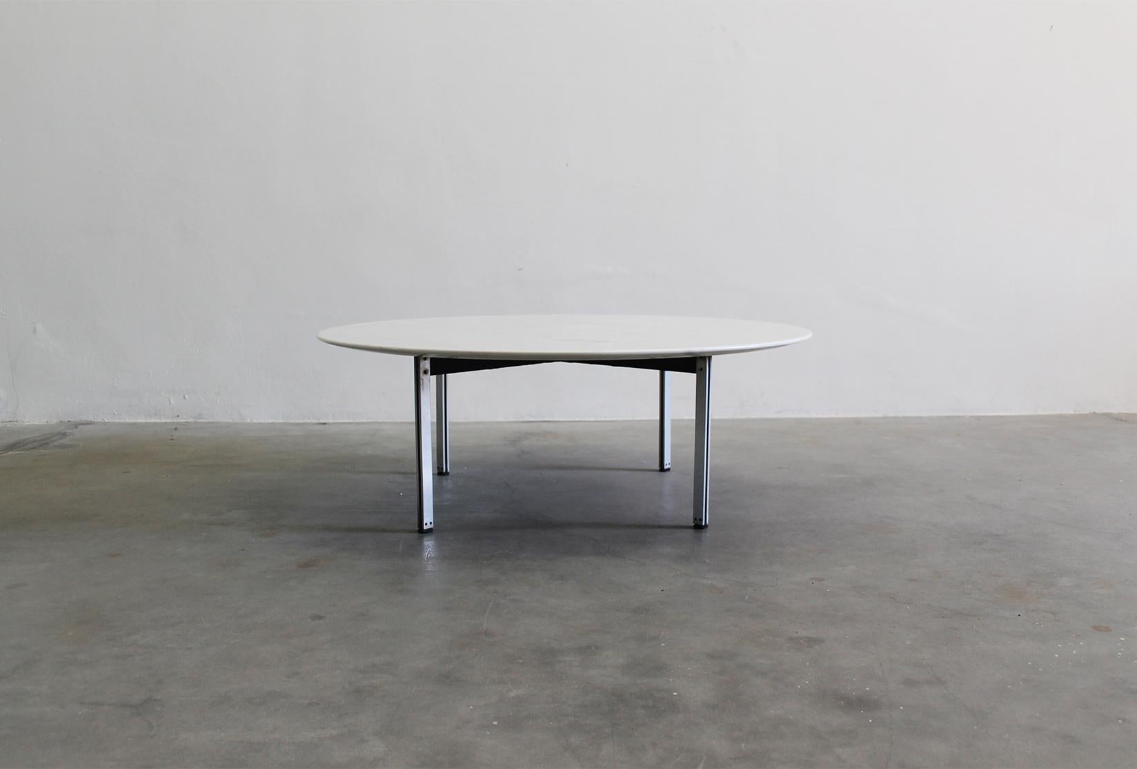 Low table with a round-shaped table top in white marble and four metal legs from the Parallel Bar series, designed by Florence Knoll and manufactured by Knoll International during the 1950s. 

Born to a baker, and orphaned at age twelve, Florence