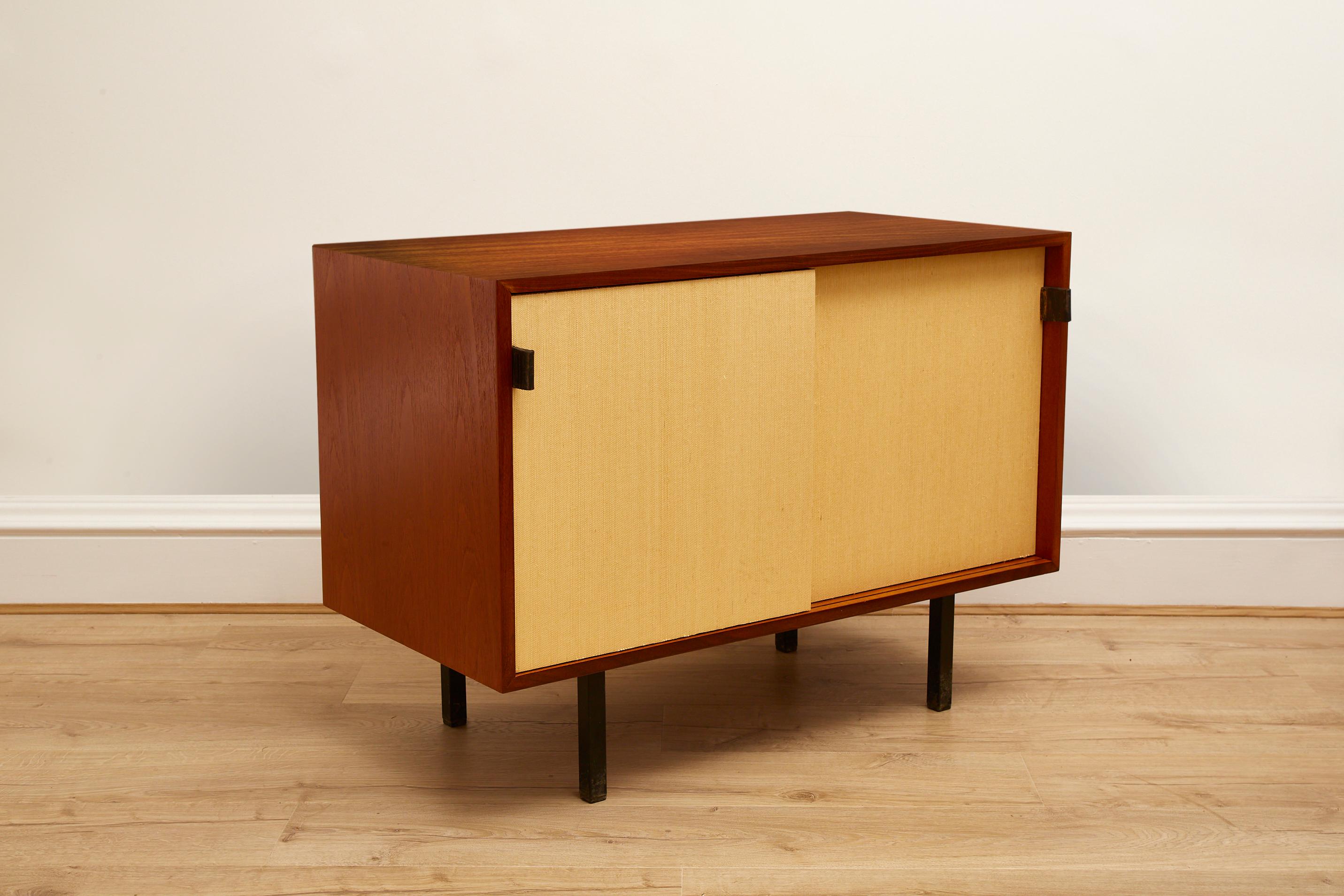 Enhance your living space with a true rare mid-century modern gem – a Teakwood and Seagrass Two Door Cabinet designed by Florence Knoll, crafted by Knoll International in the 1960's. 

This iconic piece of furniture encapsulates the design ethos of