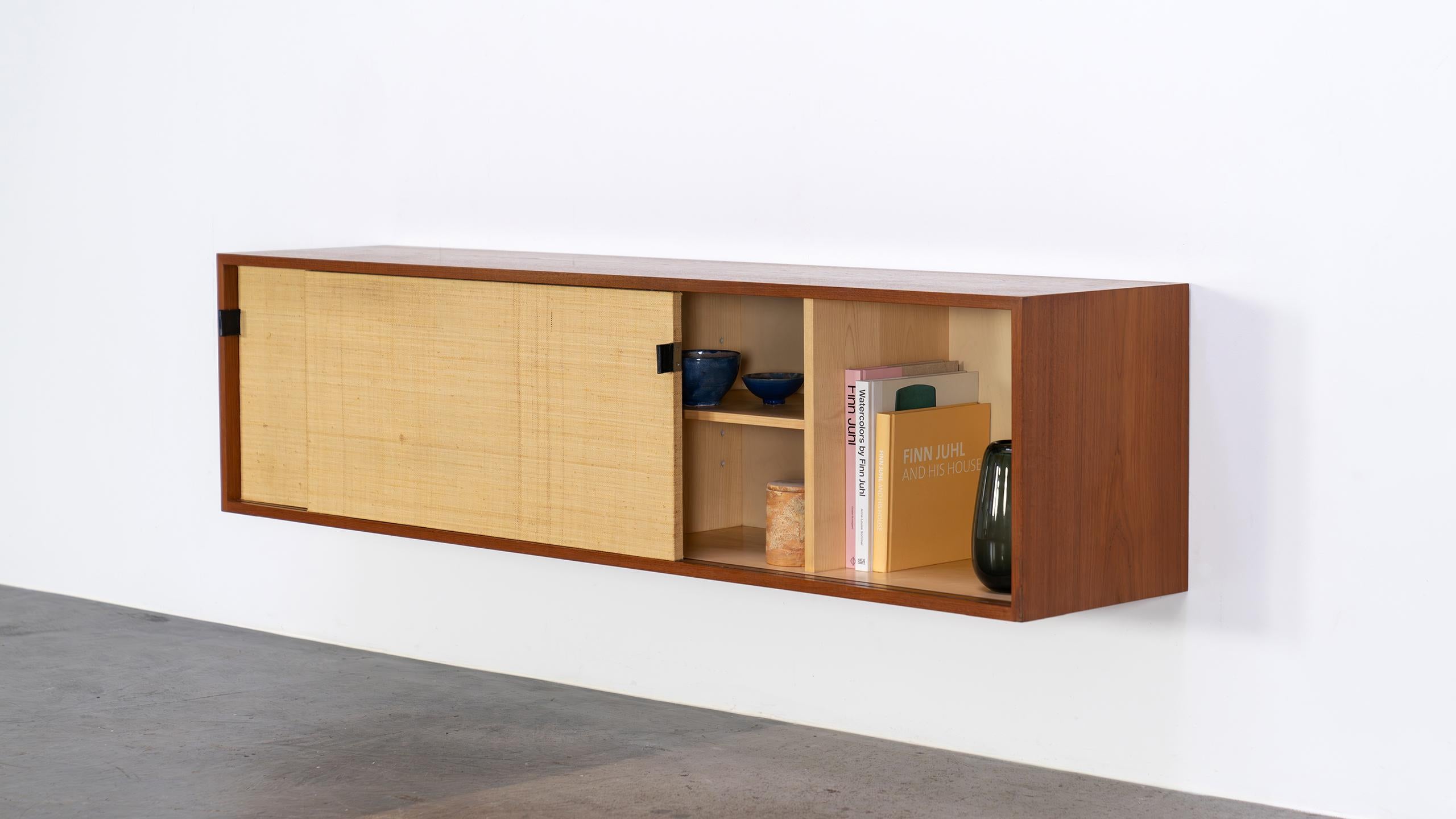 Extremely rare wall-hung sideboard (Mod°123) from 1952, designed by Florence Knoll for Knoll International - this version was produced in 1952 in a small edition by Knoll in Stuttgart.

The sliding doors are woven with seagrass, a beautiful, warm