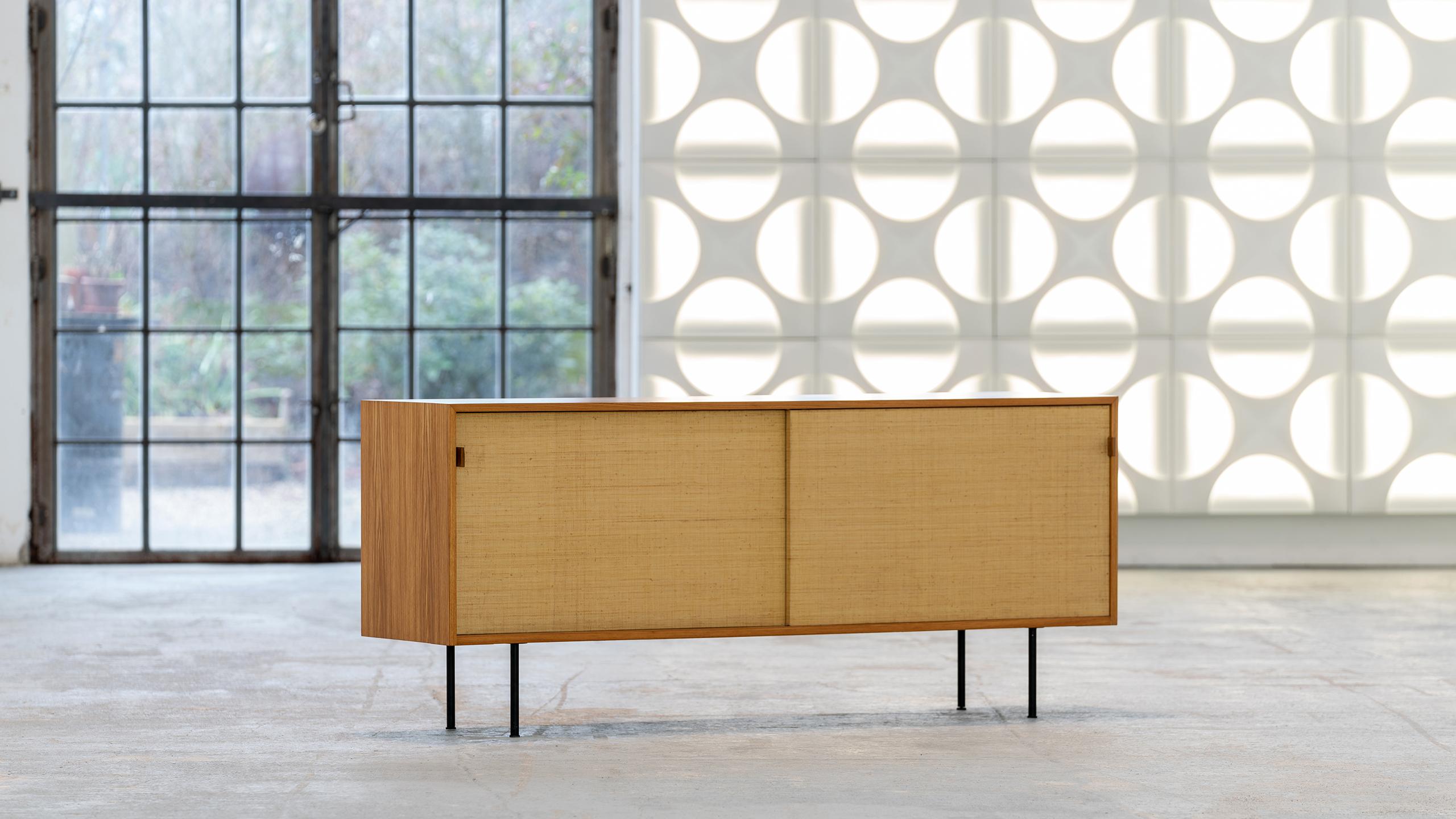 Sideboard (Mod°123) from 1968, designed by Florence Knoll for Knoll International - this version was produced in 1968 by Knoll International in Stuttgart.

The sliding doors are woven with Seagrass, a beautiful, warm and subtle detail. 
Stitched