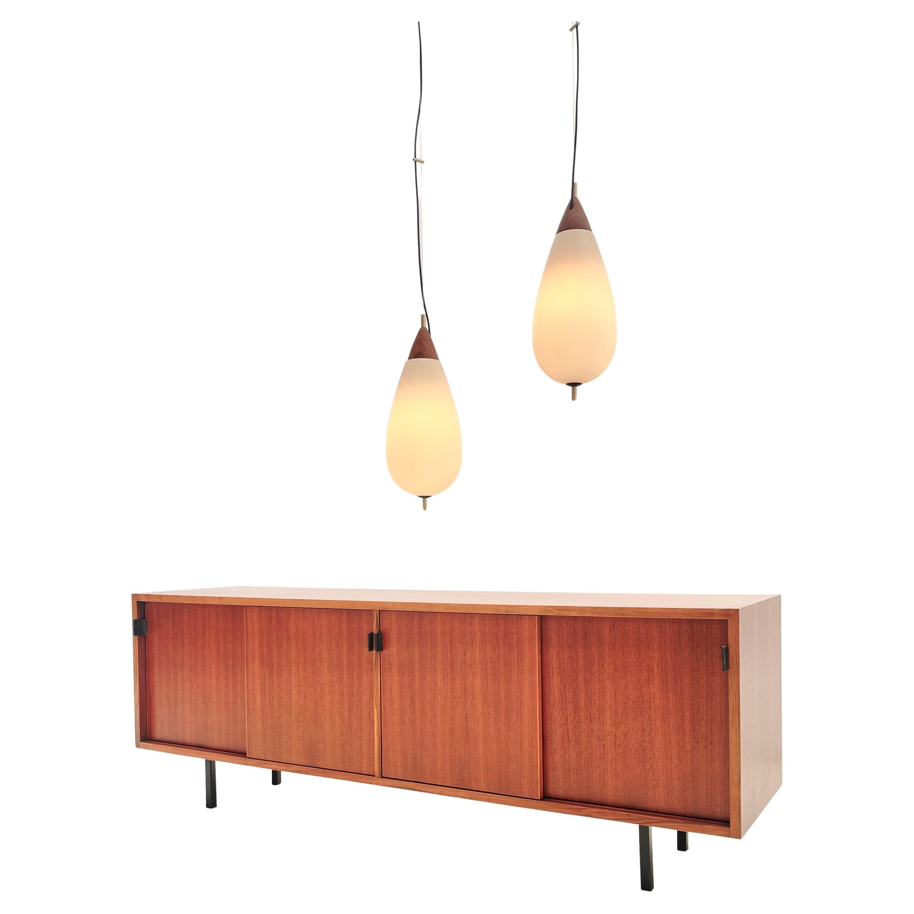 Raro aparador de 4 puertas de Florence Knoll con tiradores de cuero negro. 

De teca oscura con marco de teca clara en la fachada. 
En perfecto estado, con una consistencia agradable debido a la edad y el uso.

No dudes en ponerte en contacto con