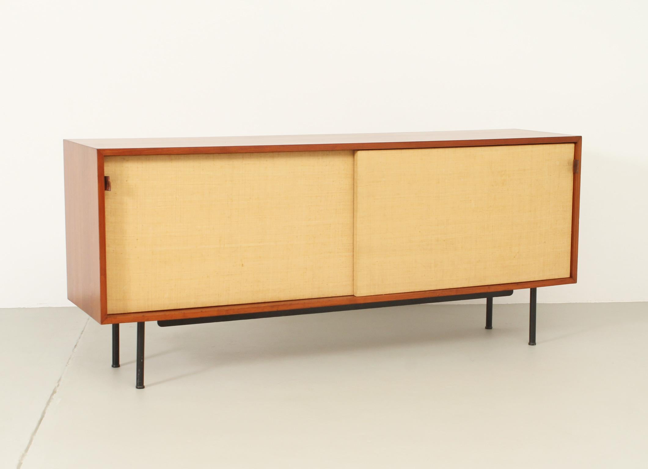 Sideboard model 116 designed by Florence Knoll in 1948 for Knoll International, USA. Early edition in teak wood with original seagrass covered sliding doors and brown leather handles, black metal bases.