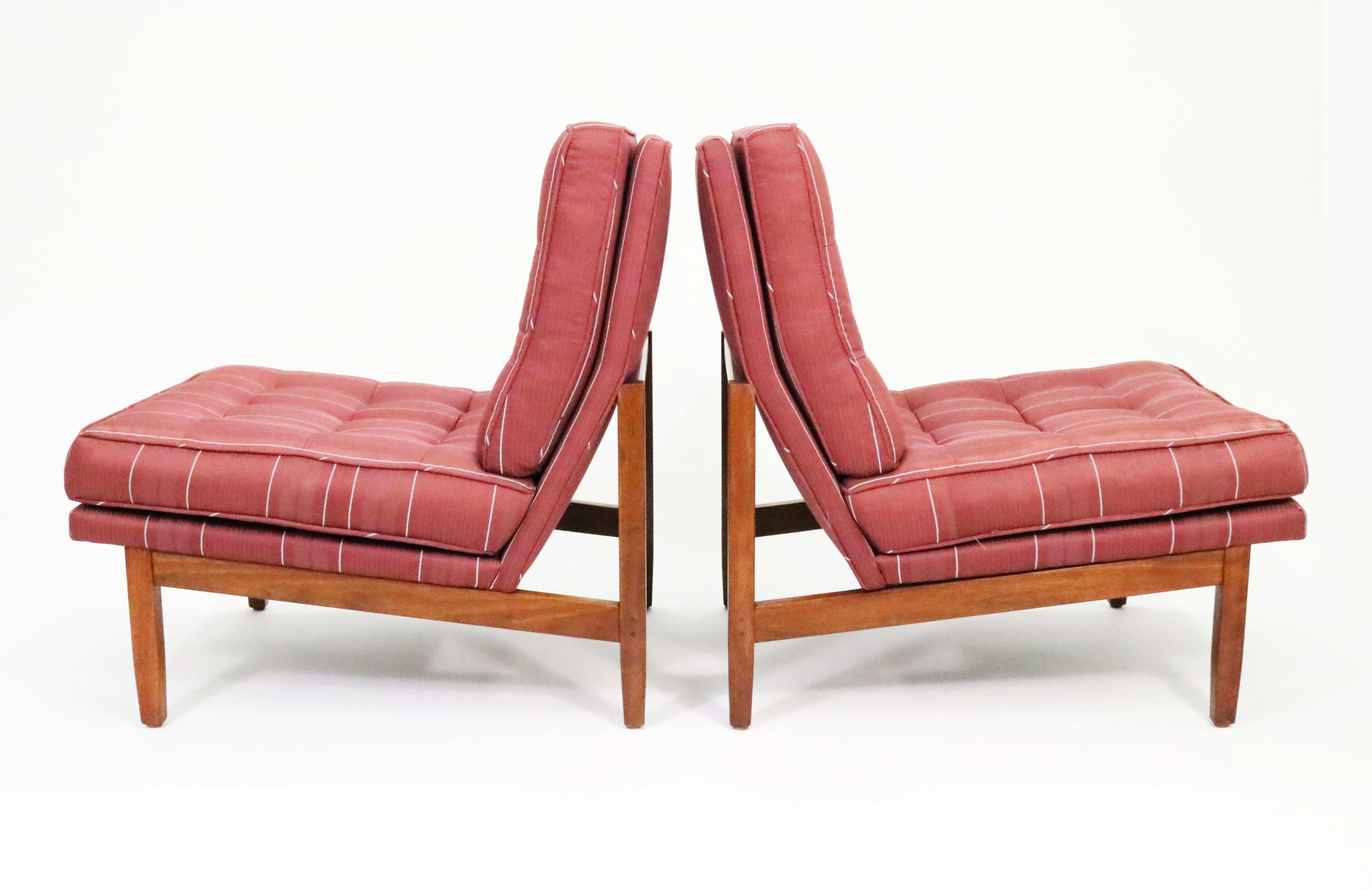 A pair of Florence Knoll's model 51W slipper lounge chairs - a brilliant take on her own metal frame parallel bar chairs executed in beautiful, richly figured walnut.

These chairs were reupholstered in the 1980s and are in need of new cushion