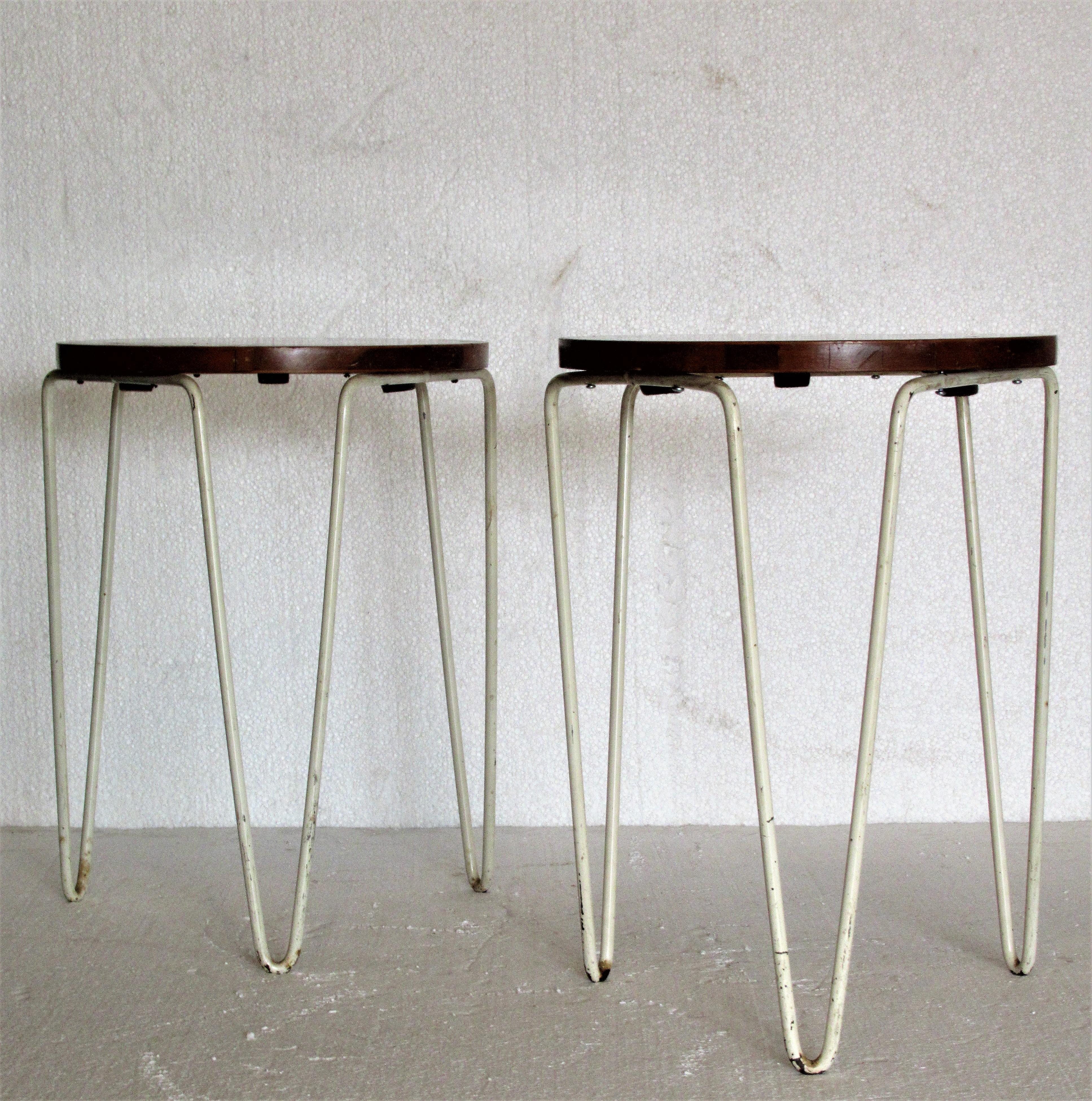 An early pair of Florence Knoll for Knoll associates stacking stools (tables) with original white enamel painted iron hairpin legs and birch wood tops. all-over nicely aged color to patina to wood and enamel painted steel, circa 1950. Look at all