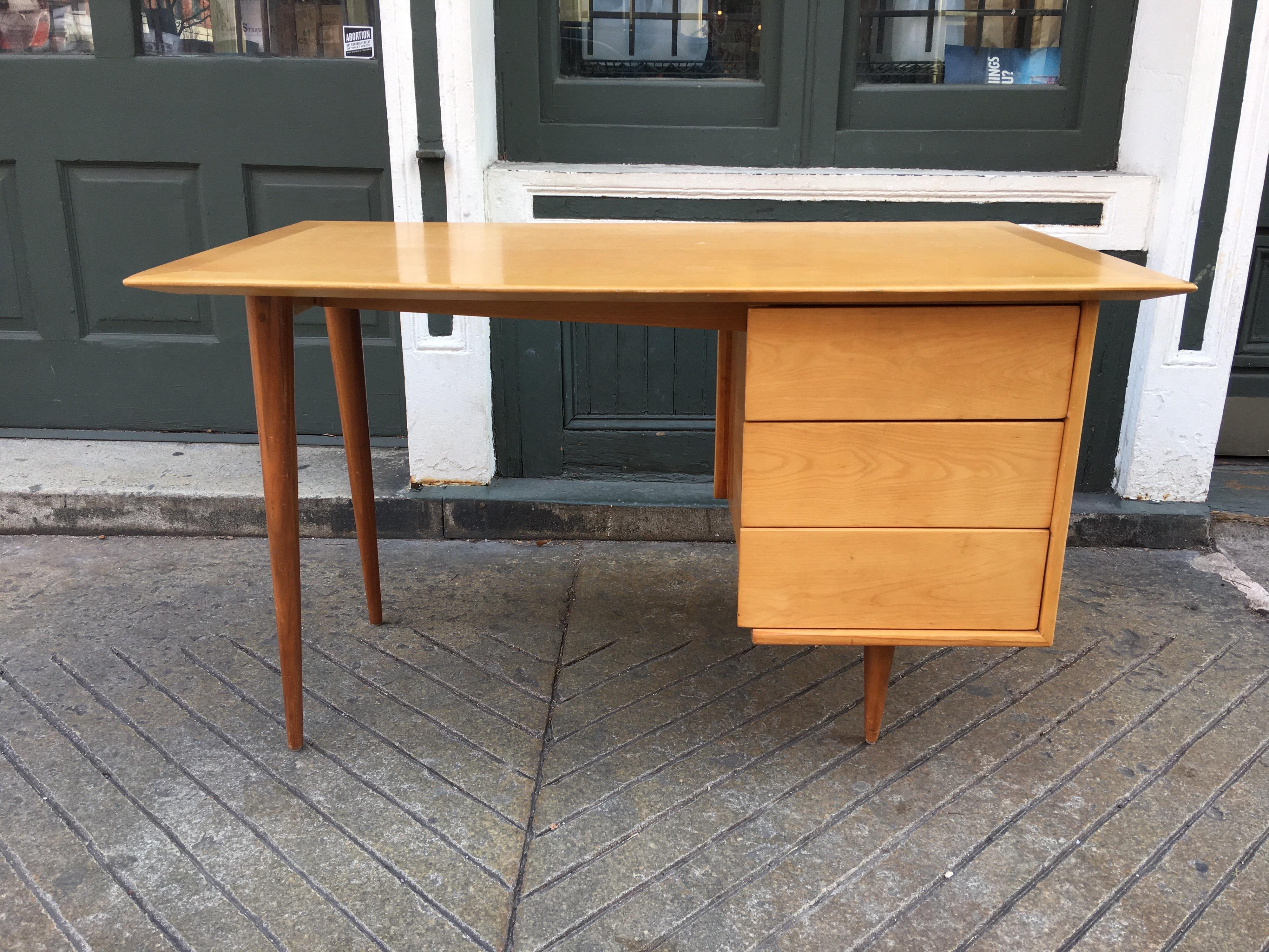 Florence Knoll style birch desk with walnut legs. Three pull out drawers on right side. Desk was refinished maybe 10 years ago and still presents very well. Nice ample work surface!