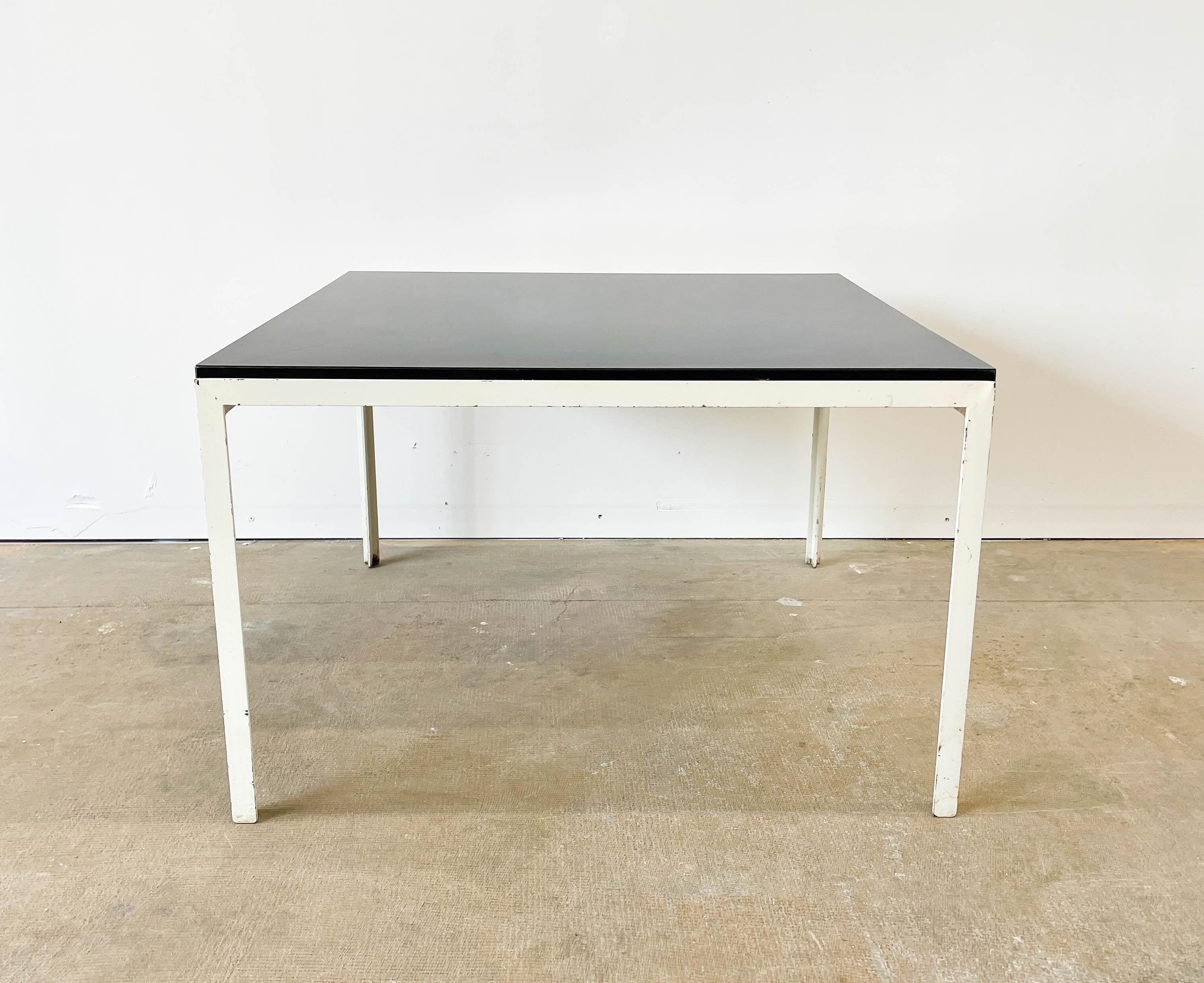 This classic steel T-Bar coffee table was designed by Florence Knoll in approximately 1952. It still retains its original Knoll Bowtie Label, confirming that it is part of an early Knoll collection from the early 1950s. The laminate top is in good