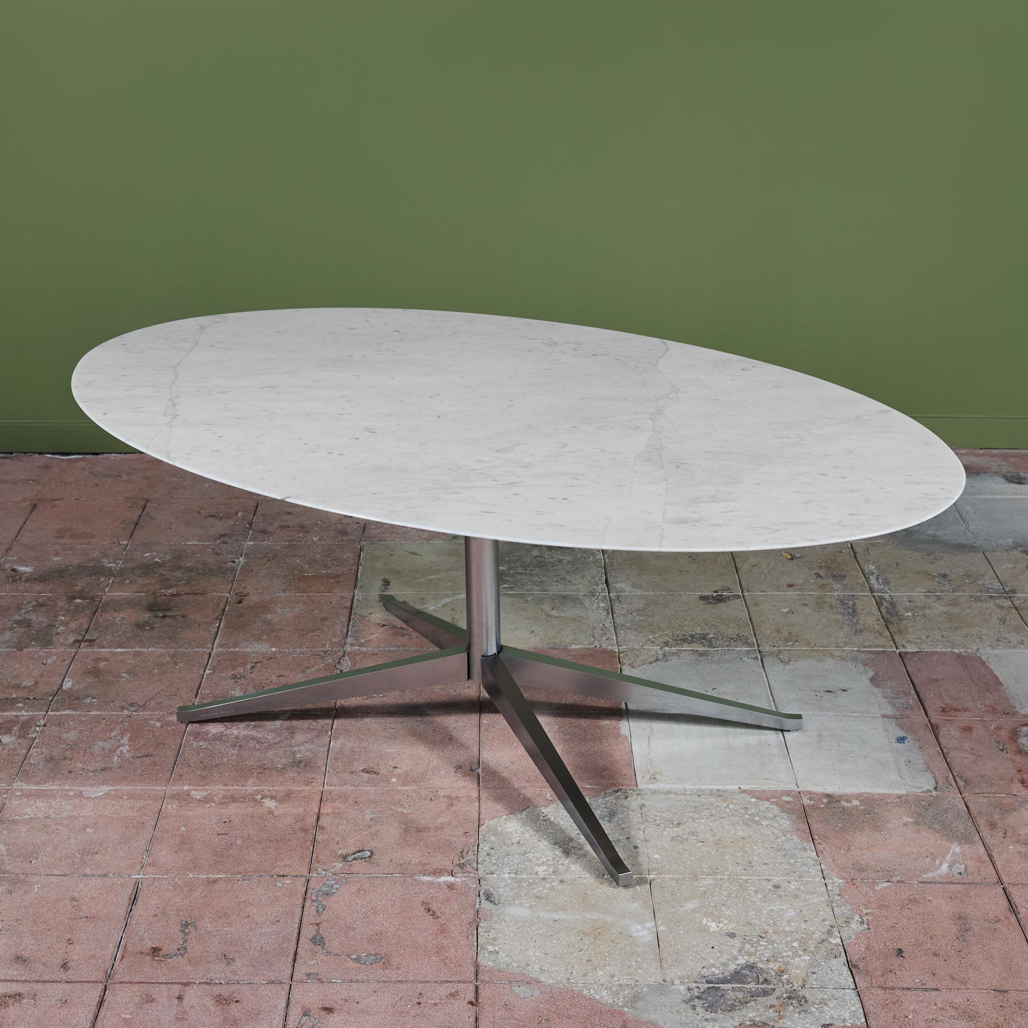 Designed by Florence Knoll in the 1960's, this simple dining table has a steel chrome plated base and gorgeous marble table top. The tabletop features a white marble with light gray and taupe veining throughout. It is perfect for dining or