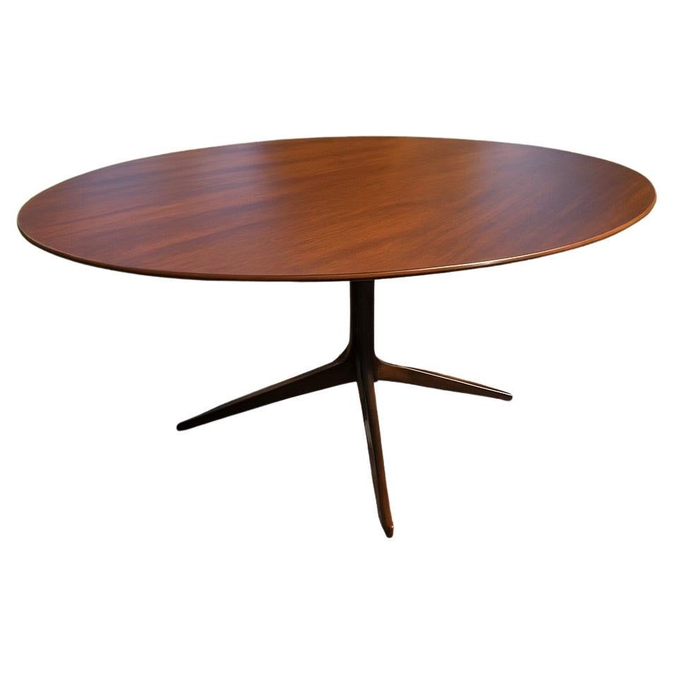 Preciosa y rara mesa americana de nogal y patas patinadas de bronce de Florence Knoll. Esta mesa es la de mayor tamaño de este modelo, lo que le da mucho encanto y realza el tablero de nogal que contrasta armoniosamente con la base patinada en