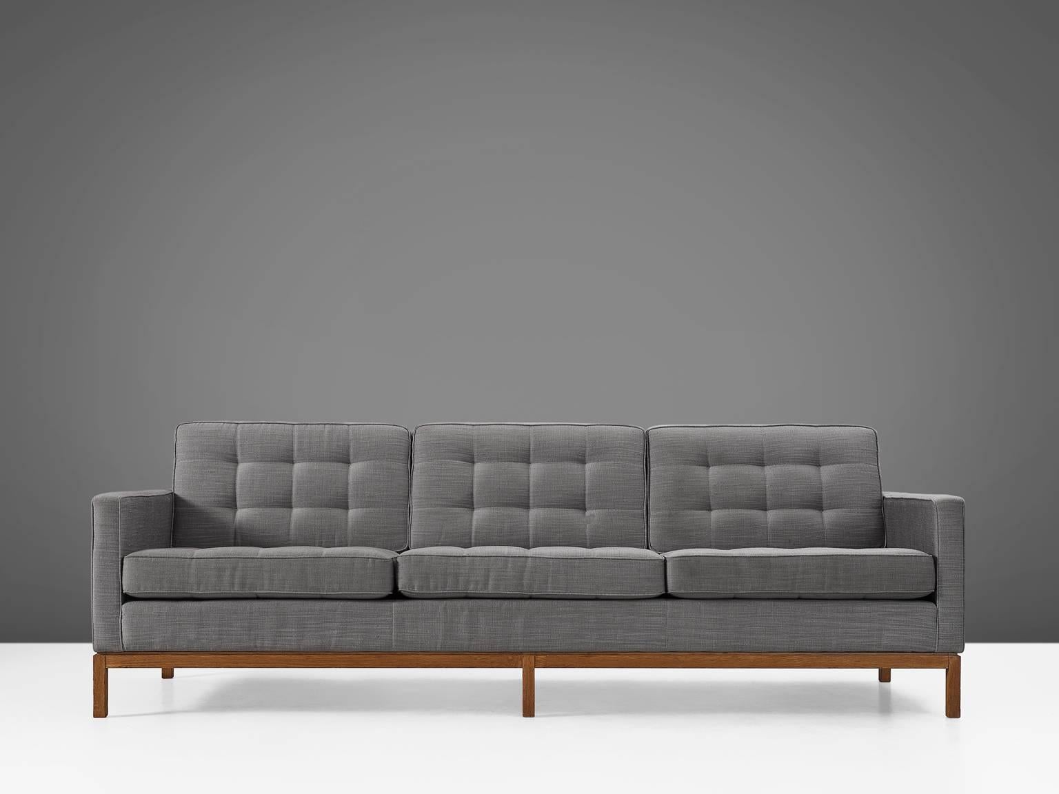 Florence Knoll for Knoll International, sofa in fabric and teak, by  United States, 1950s.

Modern sofa with teak wooden base and grey fabric upholstery. The design of this sofa is simplistic. A tight shell with armrests and six loose cushions,