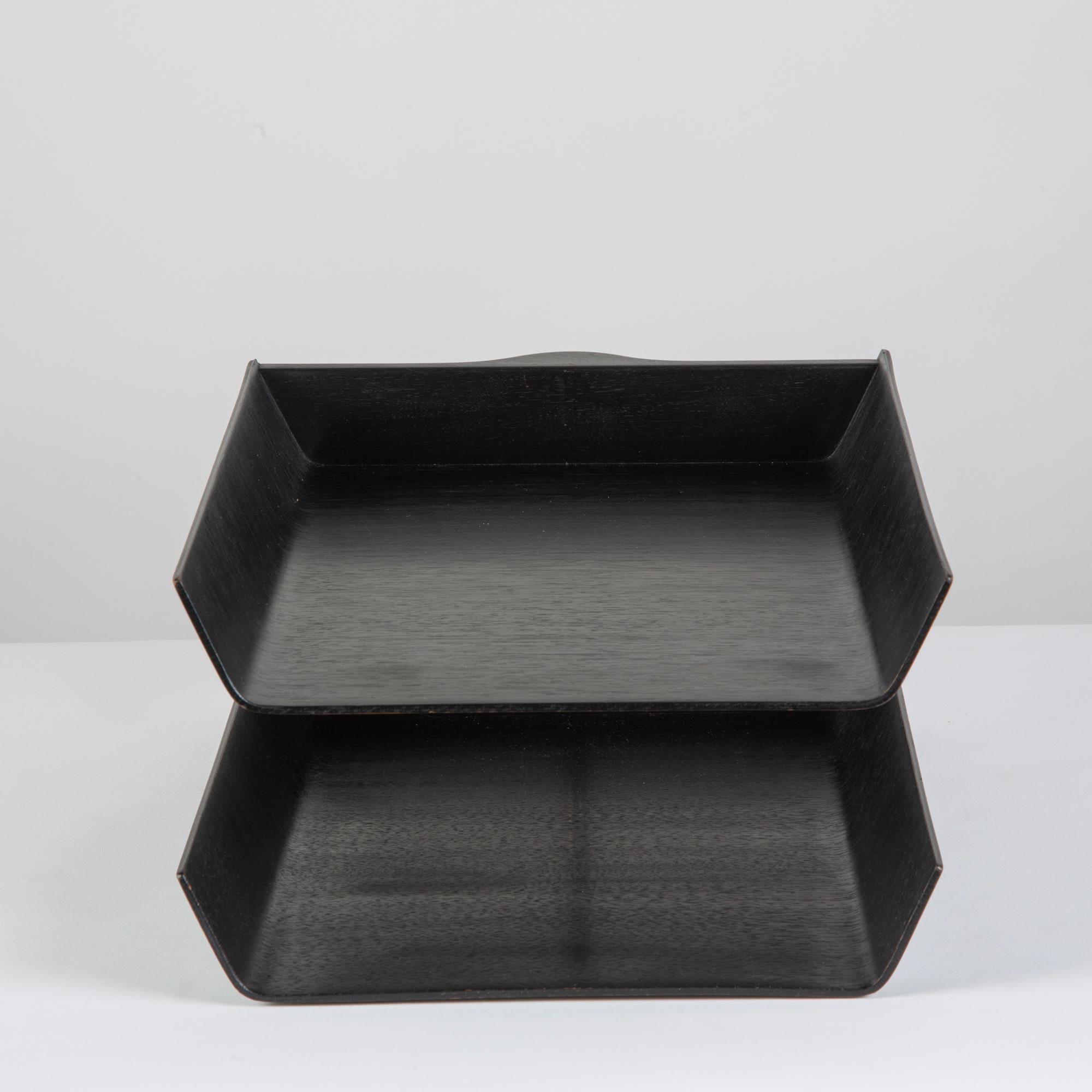 Paper tray designed by Florence Knoll in 1948. This two tier paper tray is composed of ebonized molded walnut plywood. The trays rotate around a rear central post of brushed aluminum.

Tray bottom retains the original manufacturer’s