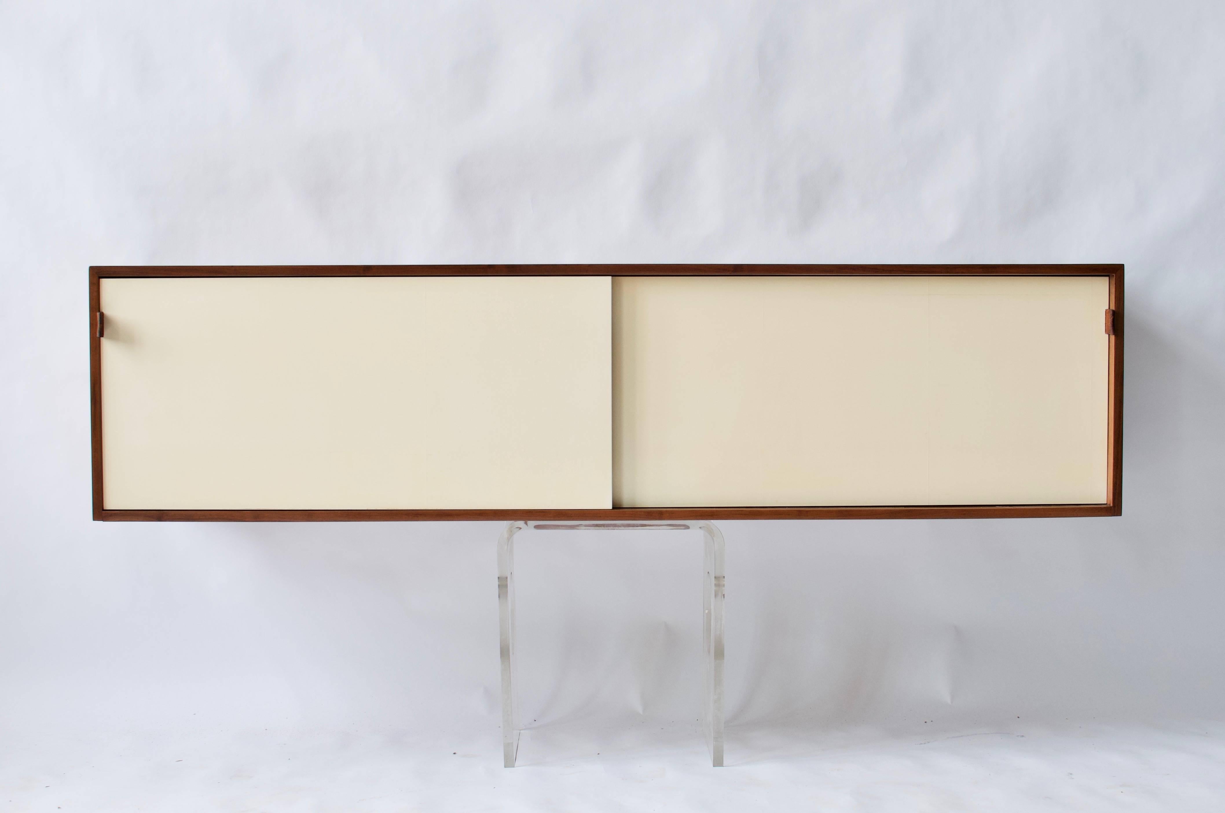 Early Florence Knoll wall hanging cabinet with two sliding doors.
(This is a wall hanging cabinet and will need to be mounted to the wall. The Lucite stand is not included in the sale.)