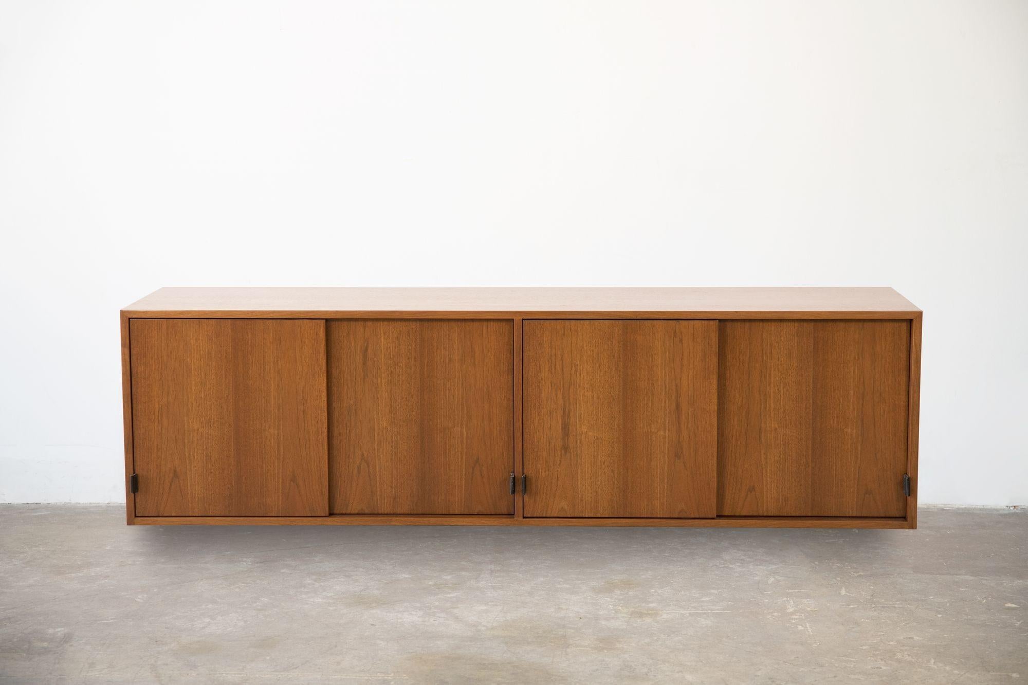 Early 1960s Florence Knoll designed wall-mount credenza with combed grain oak interiors.
Refinished and ready to install. We have two matching cabinets currently available. Original Leather pulls intact. Label on the reverse.
 
Florence Knoll