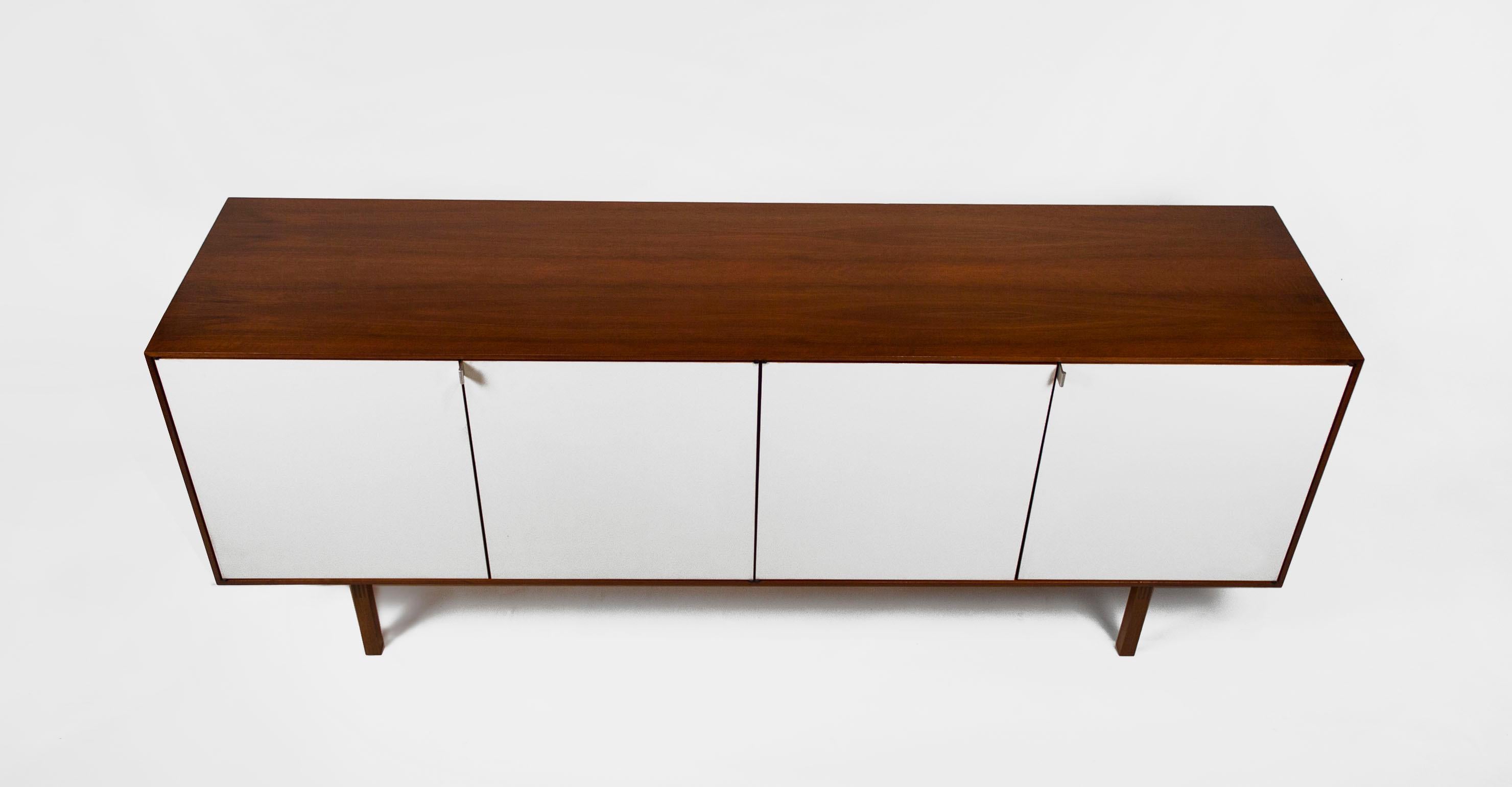 Early Model 541 credenza designed by Florence Knoll and Produced in the Knoll factory in Stuttgart Germany, the birthplace of Hans Knoll. The piece consists of walnut exterior cabinetry with maple interiors, drawers and adjustable shelves. This