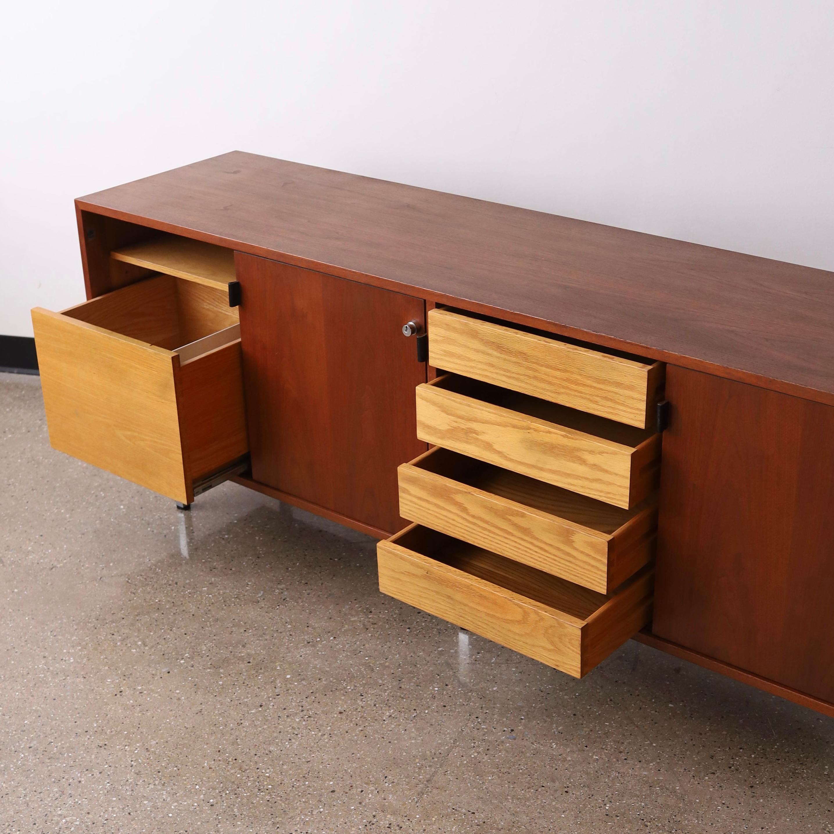 c. 1960s or 70s in great vintage condition. This piece comes with its’ original keys that lock the doors and it retains its’ original leather pulls. There are multiple drawers and removable / modular shelves. The only notable flaws are a spot of
