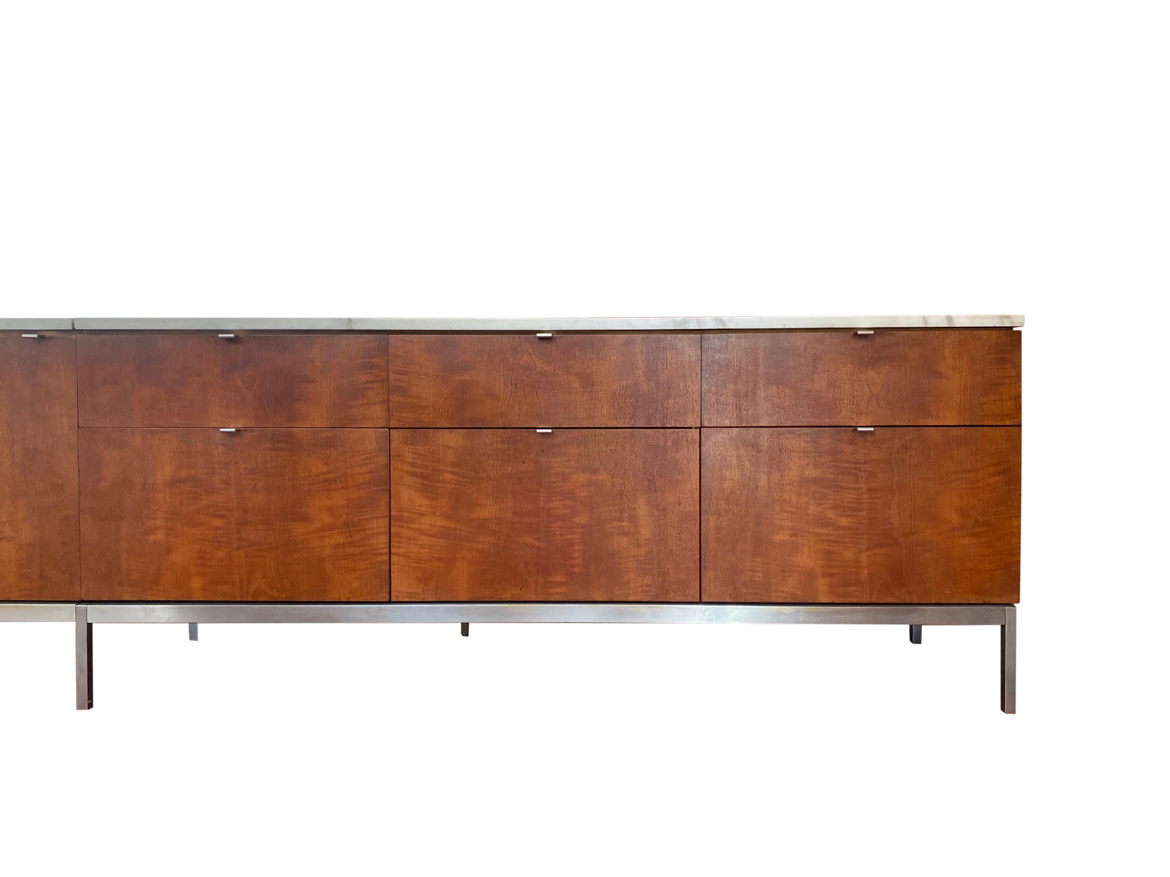 Florence Knoll credenza in walnut with a calacatta marble top and chrome metal frame. Optional central locking system. When Florence Knoll revolutionized private office design by replacing the typical executive desk with a table desk, she needed a