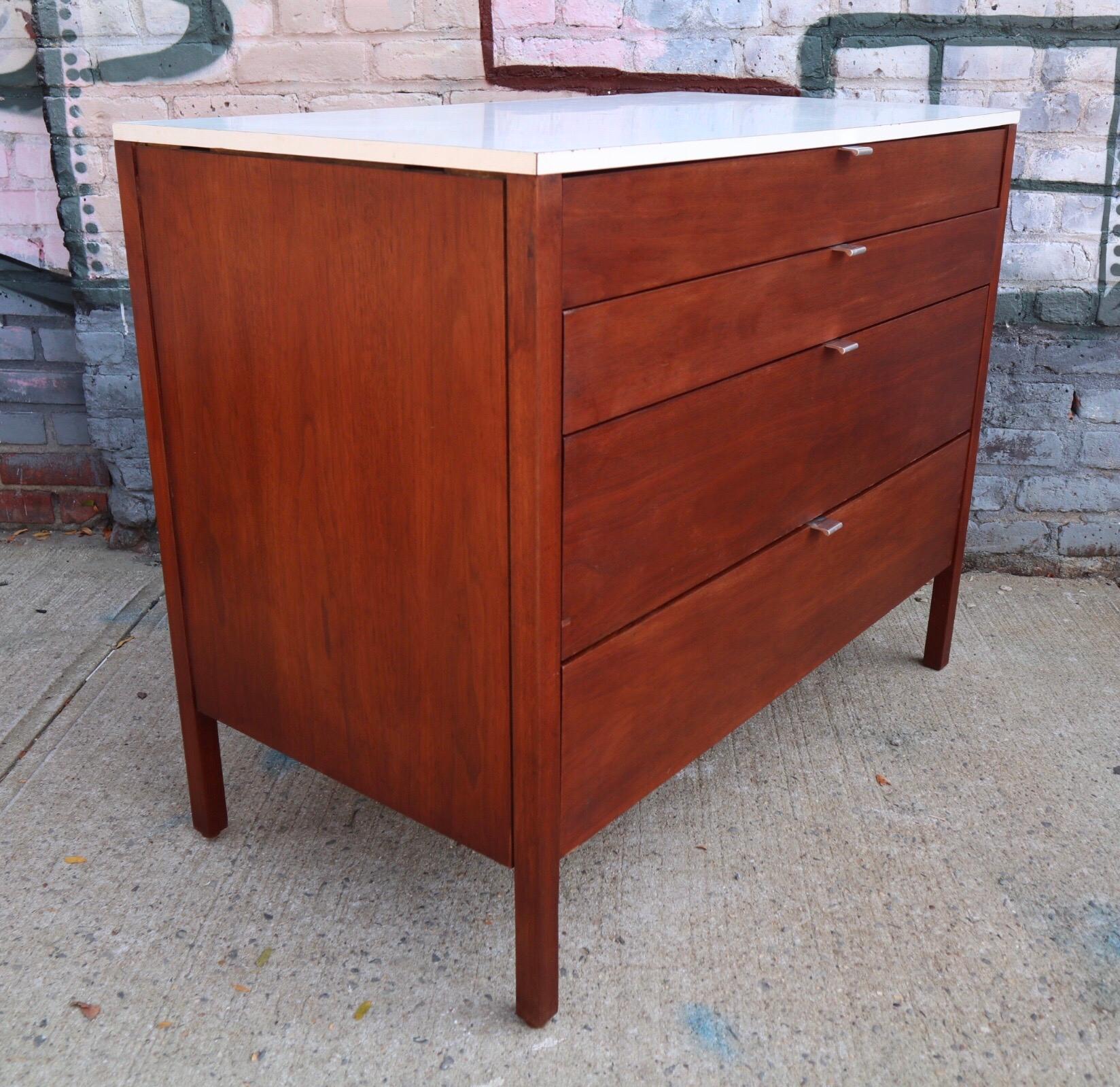 Gorgeous walnut Florence Knoll dresser. Signed with Early bowtie label in top drawer. All drawers function smoothly. Wood exterior has been refinished. White laminate top in good condition.