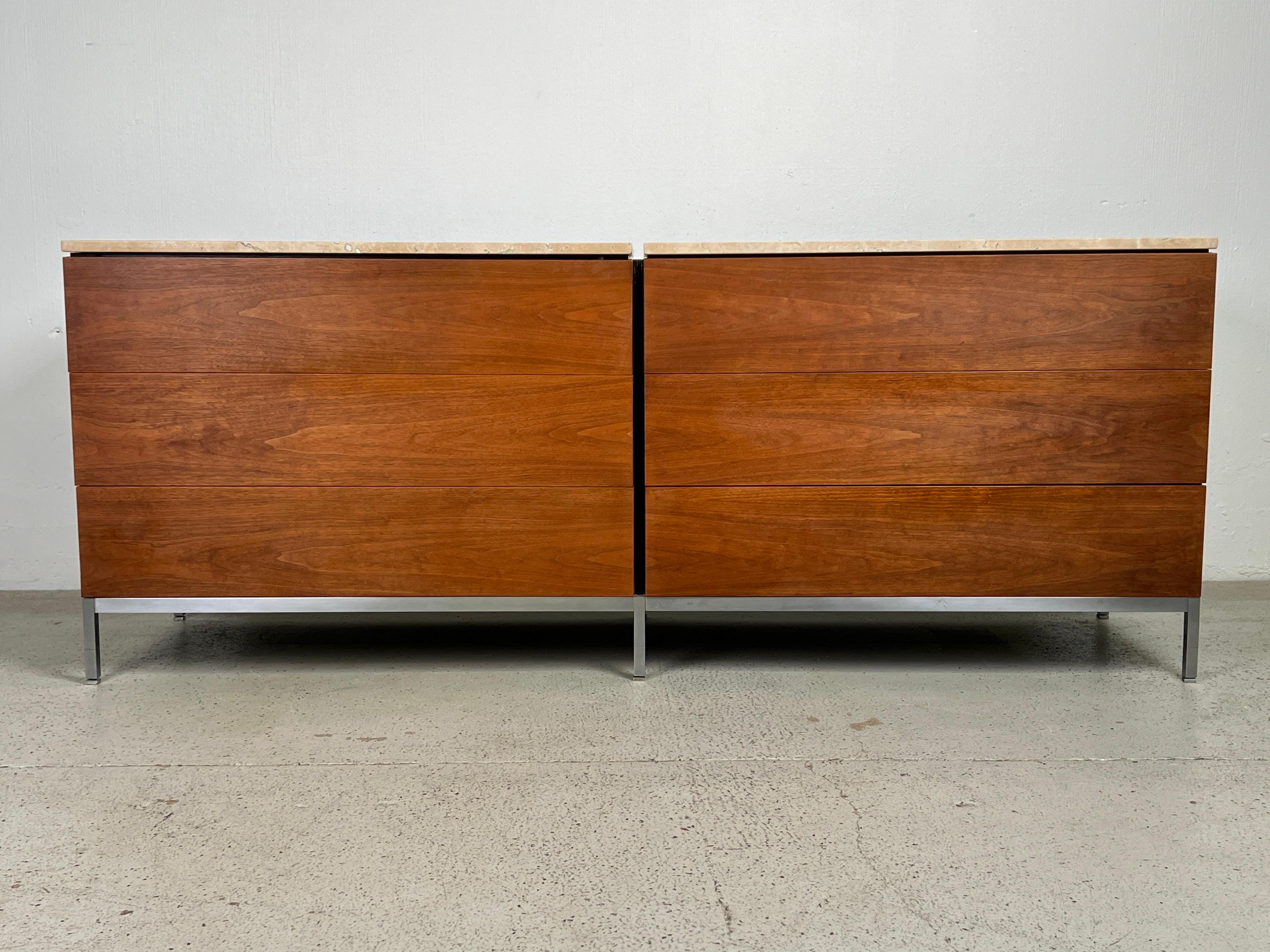 A walnut chest of drawers with brushed steel base and travertine top. Designed by Florence Knoll for Knoll. 