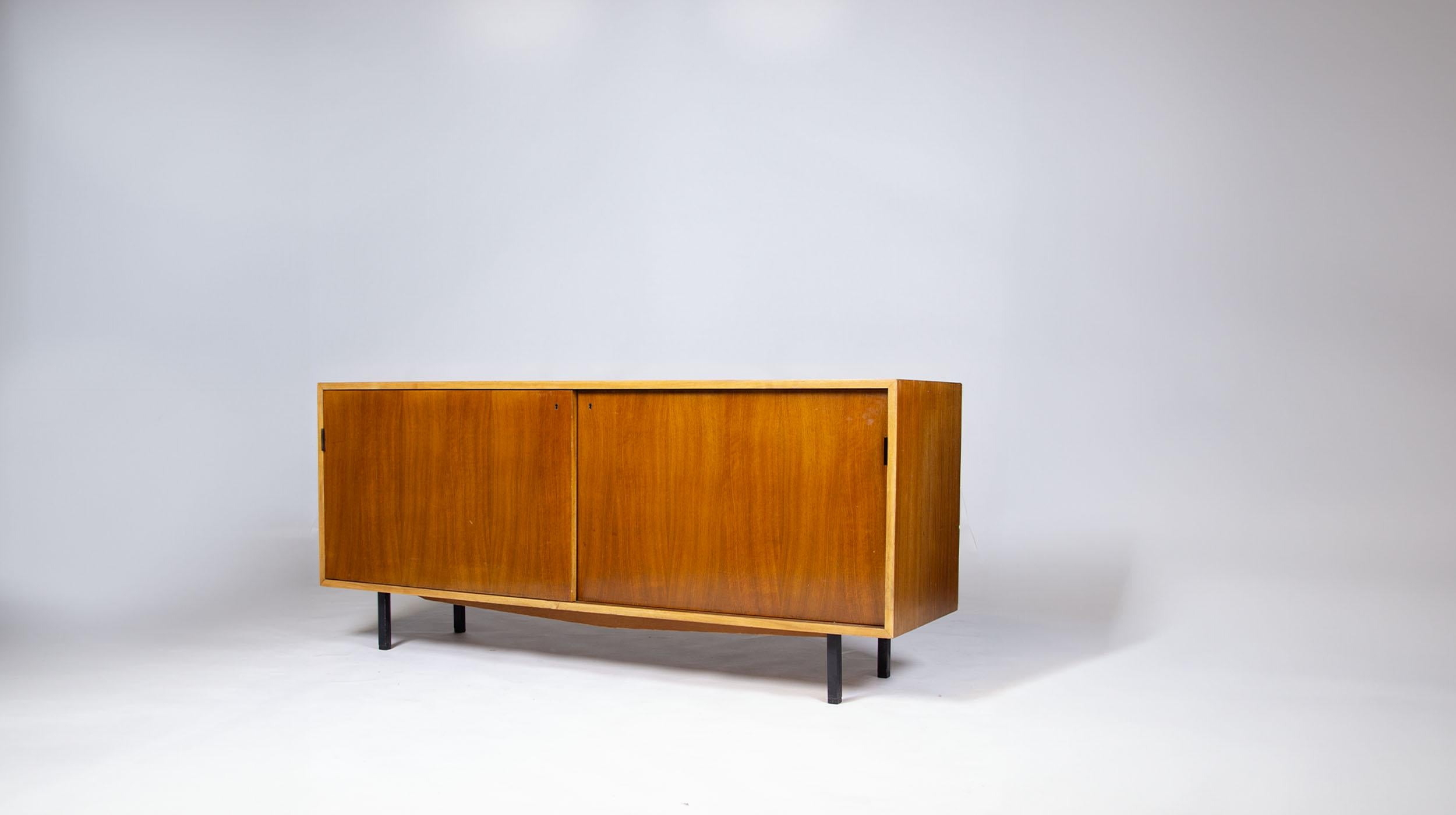 Florence Knoll walnut sideboard, Knoll International edition, 1960s.

Stamped on the back with the Knoll International plaque.

Opening with two sliding doors and black lacquered steel handles. First version with its antique lock (does not have the