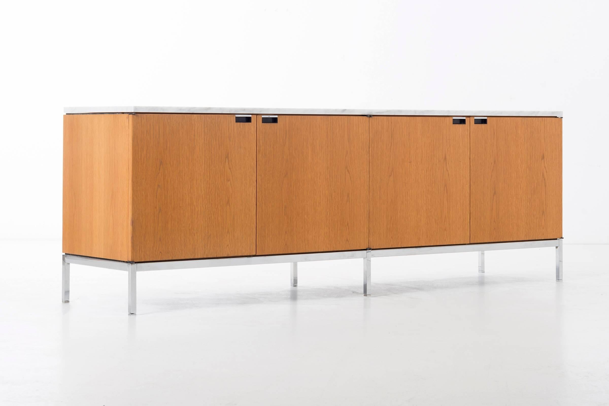Florence Knoll white oak credenza with Carrara marble top.
Features 8 doors with cutout pulls, 4 separate storage compartments with adjustable shelves  
Solid tubular base with adjustable feet.
[label Knoll on underside]    