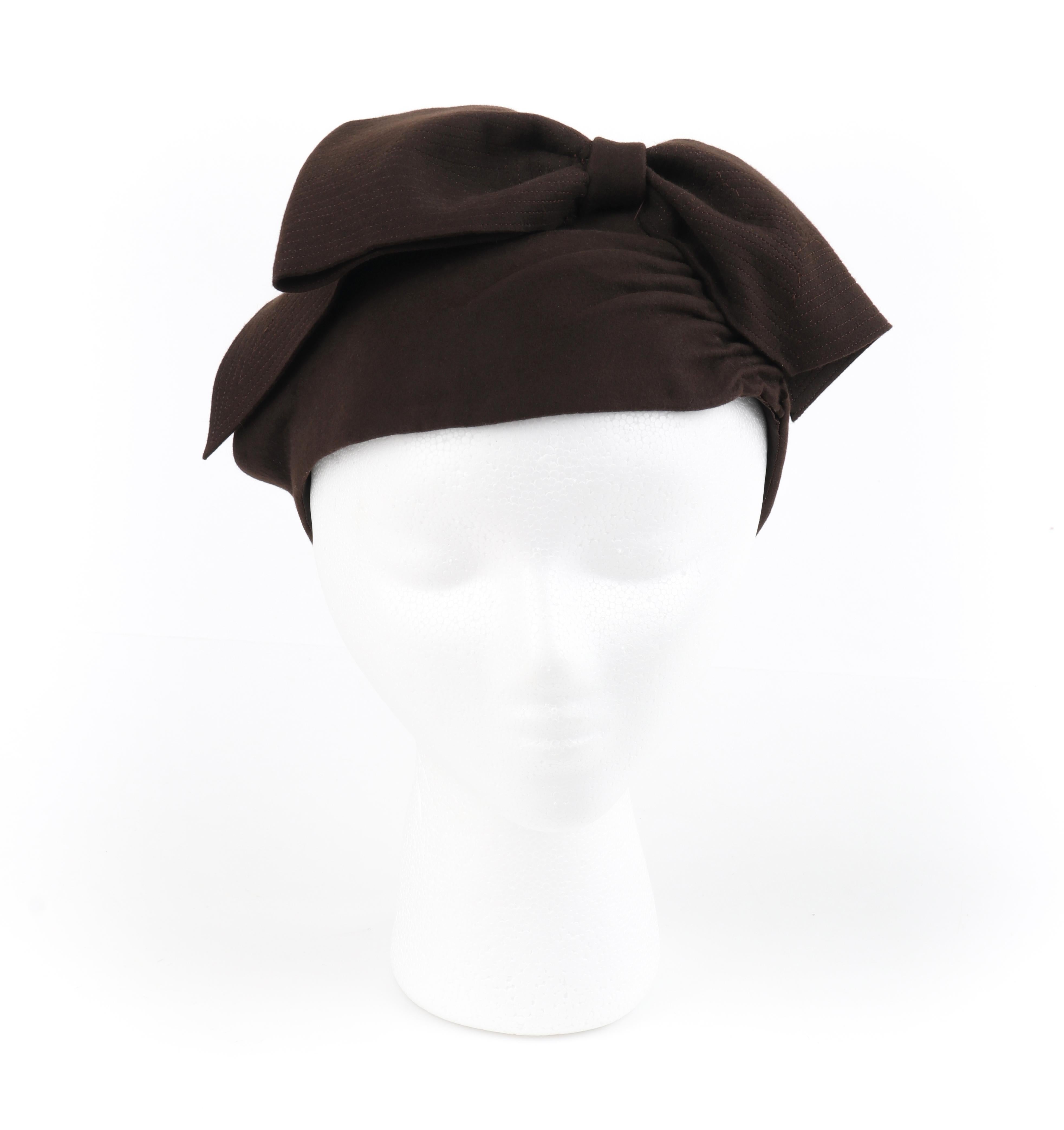 FLORENCE MILLINERY COUTURE c.1940s Chocolate Brown Felt Front Bow Turban Hat
 
Circa: 1940’s
Label(s): “Florence” Millinery, Glencoe Illinois
Style: Turban hat
Color(s): Chocolate brown (exterior, interior)
Lined: No
Unmarked Fabric Content: Felt