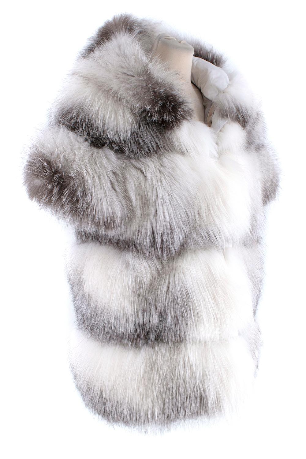 Florence Mode Fox Fur Hooded Gilet

-Fox fur fur jacket in white with grey tones.
-The processing of this garment is on horizontal side -Layered panels of fur 
-The clasp consists of hooks
-A snuggly hood 
-Two inset pockets 
-Silk lining