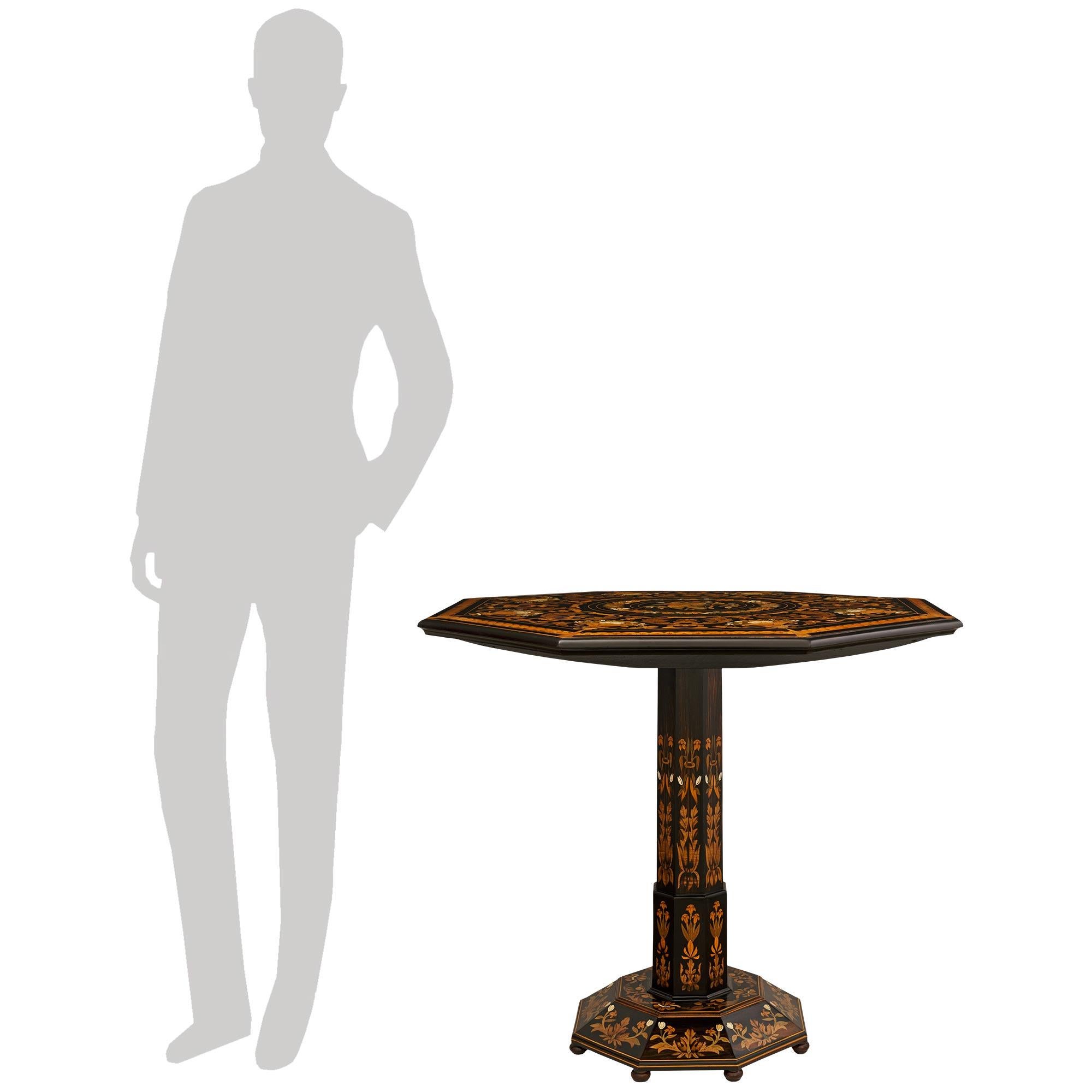 A sensational and extremely high quality Florentine 19th century Fruitwood, Exotic Wood, Mother of Pearl and Bone tilt top center table, by Falcini. This stunning octagon shaped table is raised on bun feet below the octagonal base decorated with