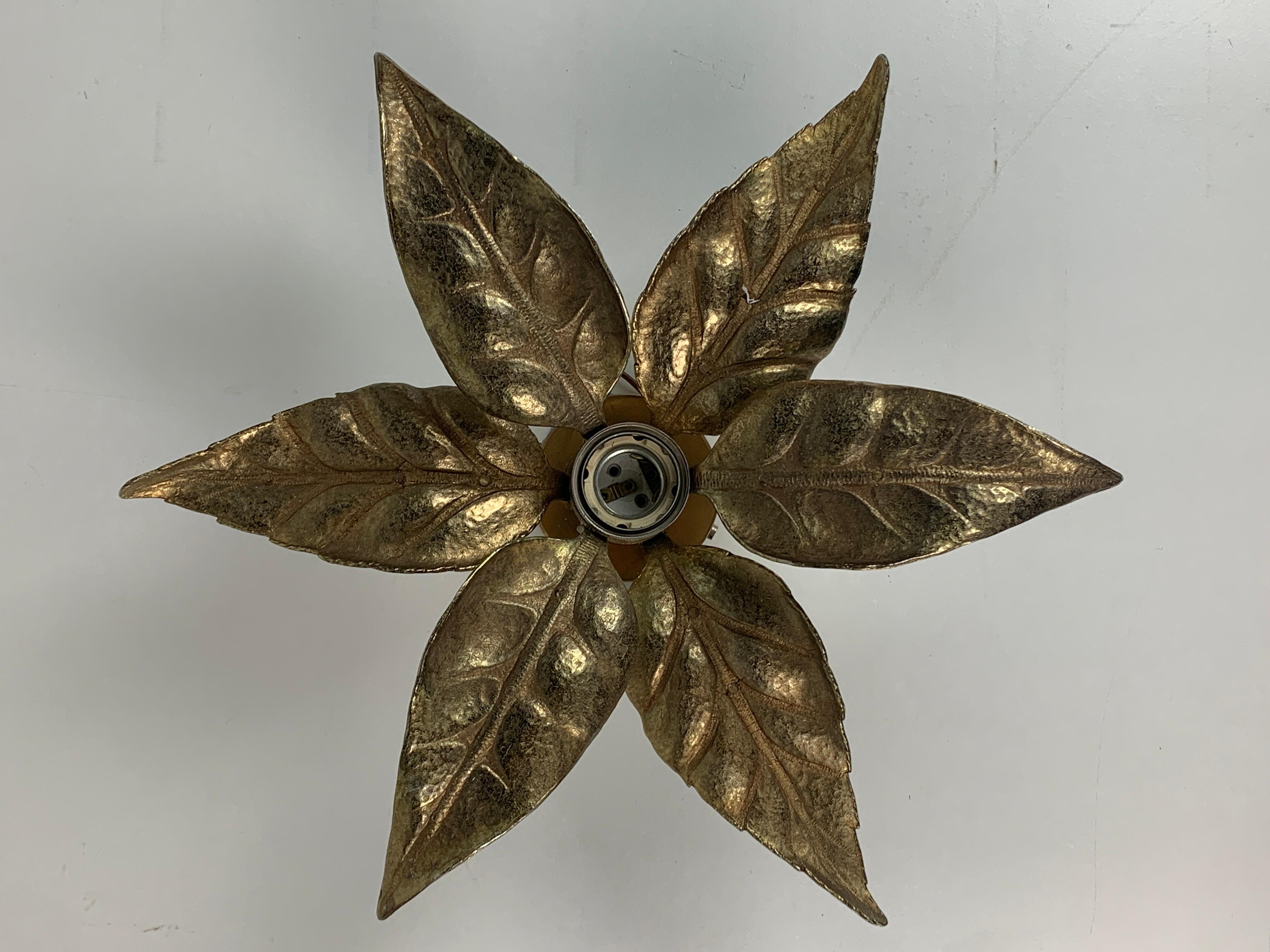 Un'applique Florentine floreale in ottone attribuita spesso a Willy Daro per Massive Lighting, Belgio anni '70. Questa iconica lampada da parete è facile da usare. Un vero pezzo d'epoca Hollywood Regency. L'ottone ha una bella patina e la lampada è