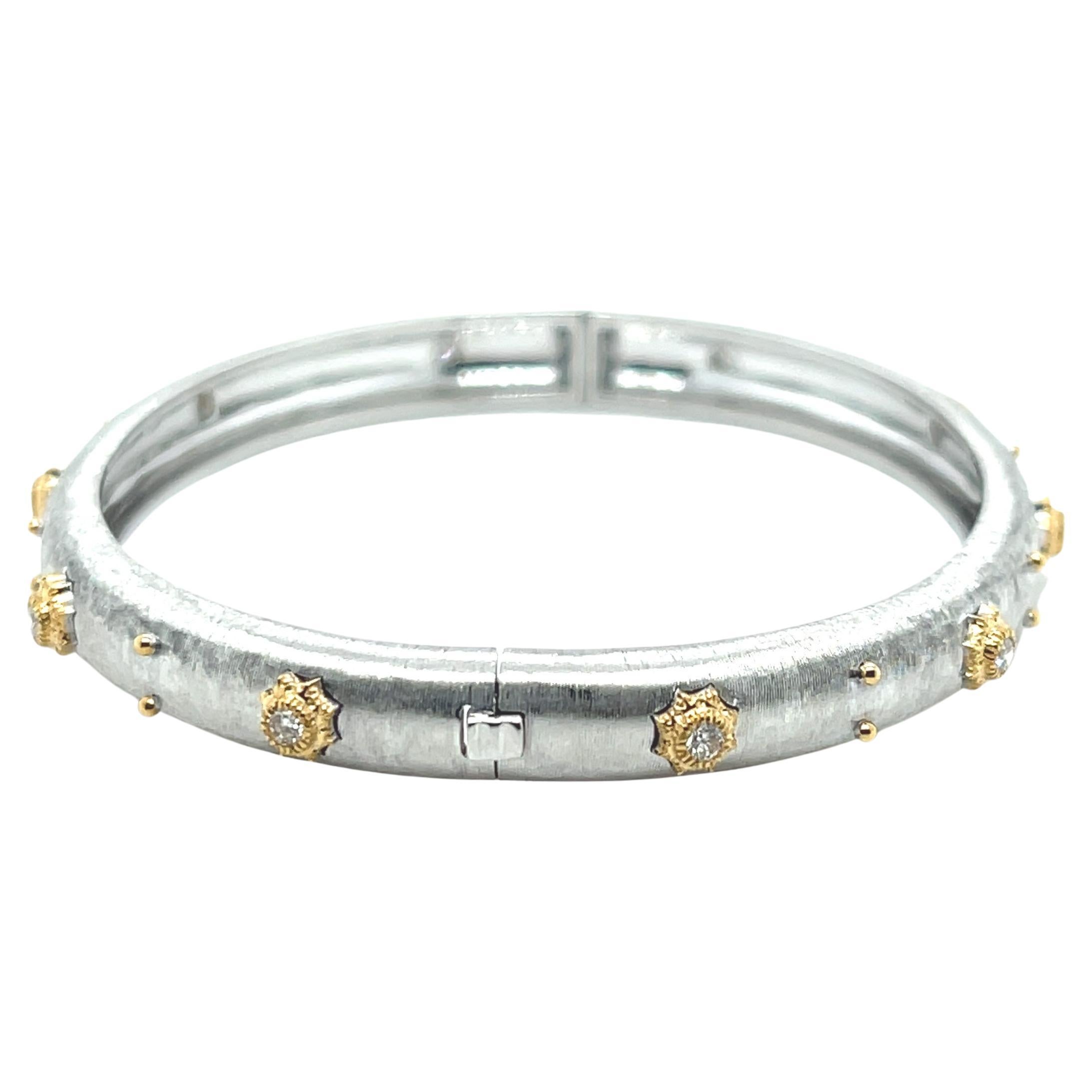 This beautiful Florentine white gold bangle bracelet is set with ten sparkling round brilliant diamonds weighing .30 carats total. Each diamond is bezel set in an 18k yellow gold finely-detailed starburst bezel. The 18k white gold bangle has an