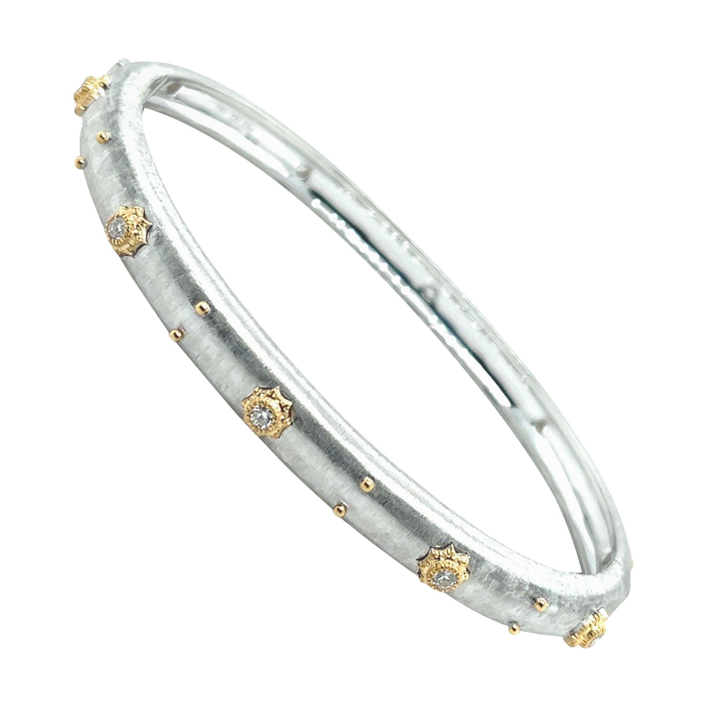 Questo bellissimo bracciale bangle in oro bianco Florentine è incastonato con dieci scintillanti diamanti tondi brillanti del peso totale di 0,30 carati. Ogni diamante è incastonato in un castone a stella in oro giallo 18 carati finemente