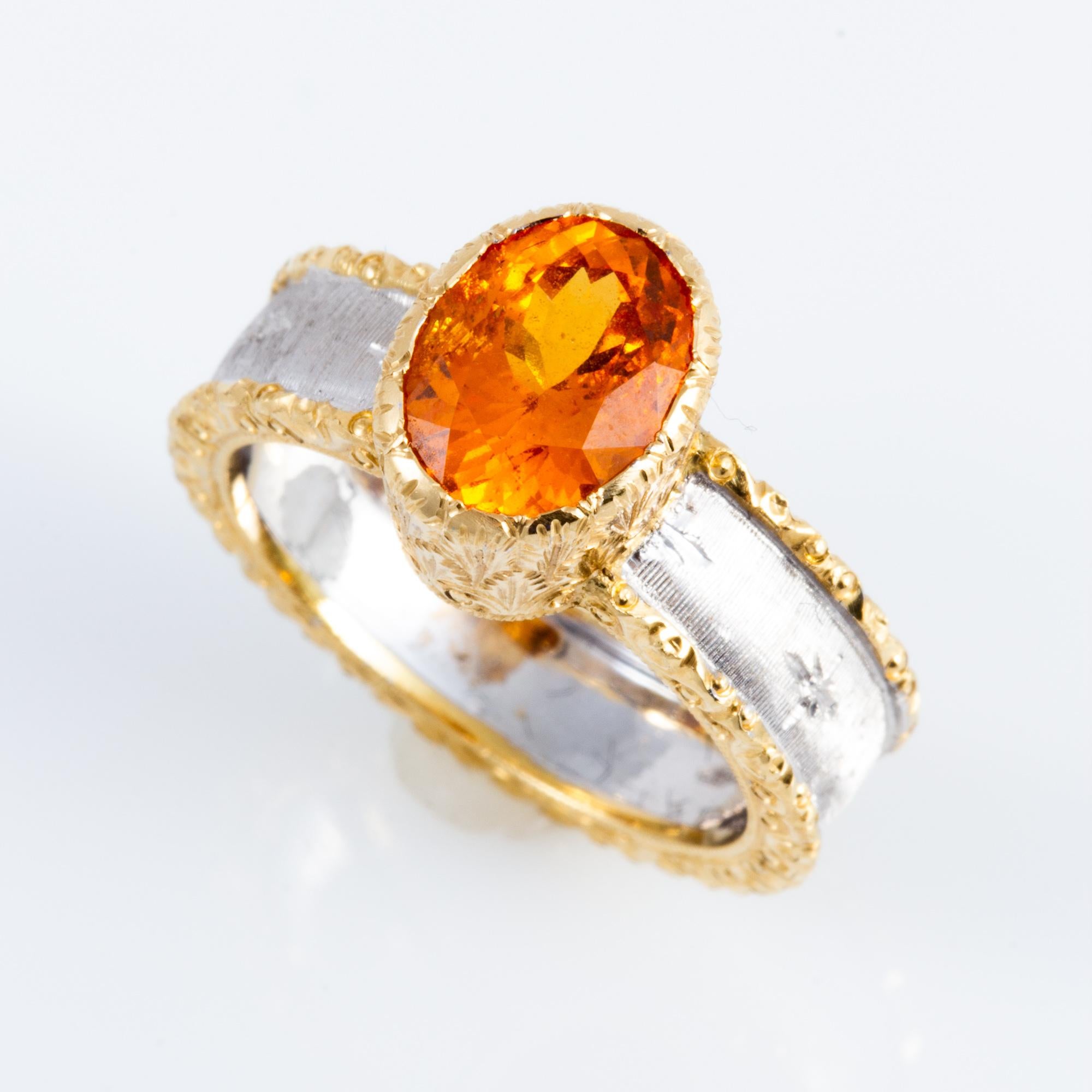 Handcrafted by Italian master jewelers in an old world Florentine style, this exquisite mandarin orange Garnet is set in a beautifully hand engraved setting in two tone 18 kt gold.  This Spessartine Garnet is 3.13 carats. Handcrafted by a small