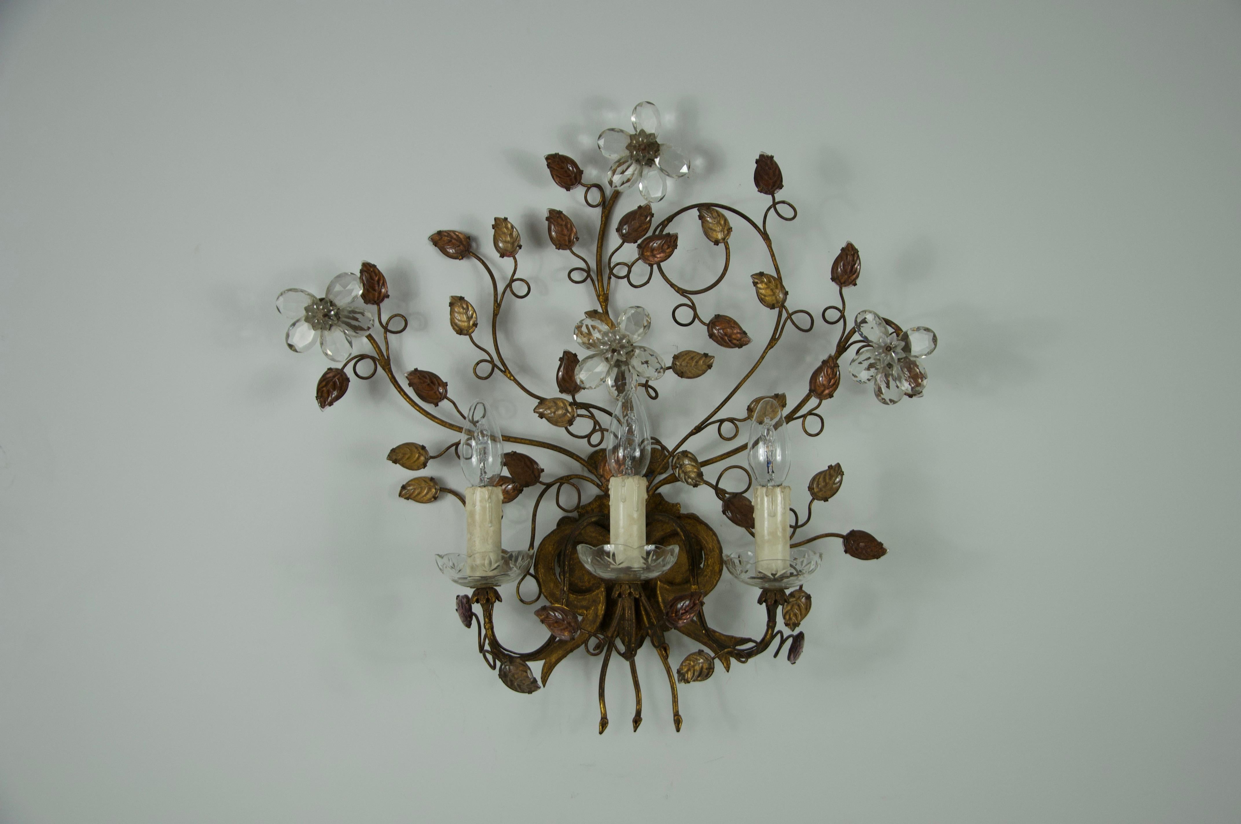 Cette exquise applique Florentine a été fabriquée par Banci Firenze en Italie dans les années 1970. La pièce présente un design très décoratif avec un arrangement délicat de fleurs stylisées et de feuilles enroulées en métal doré, caractéristique de